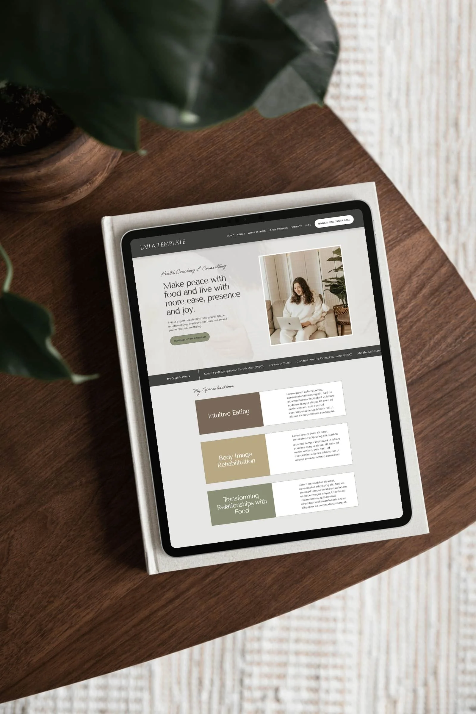 A laptop on a wooden table displays a wellness website for an Intuitive Eating Counsellor created by a skilled Squarespace website designer and copywriter
