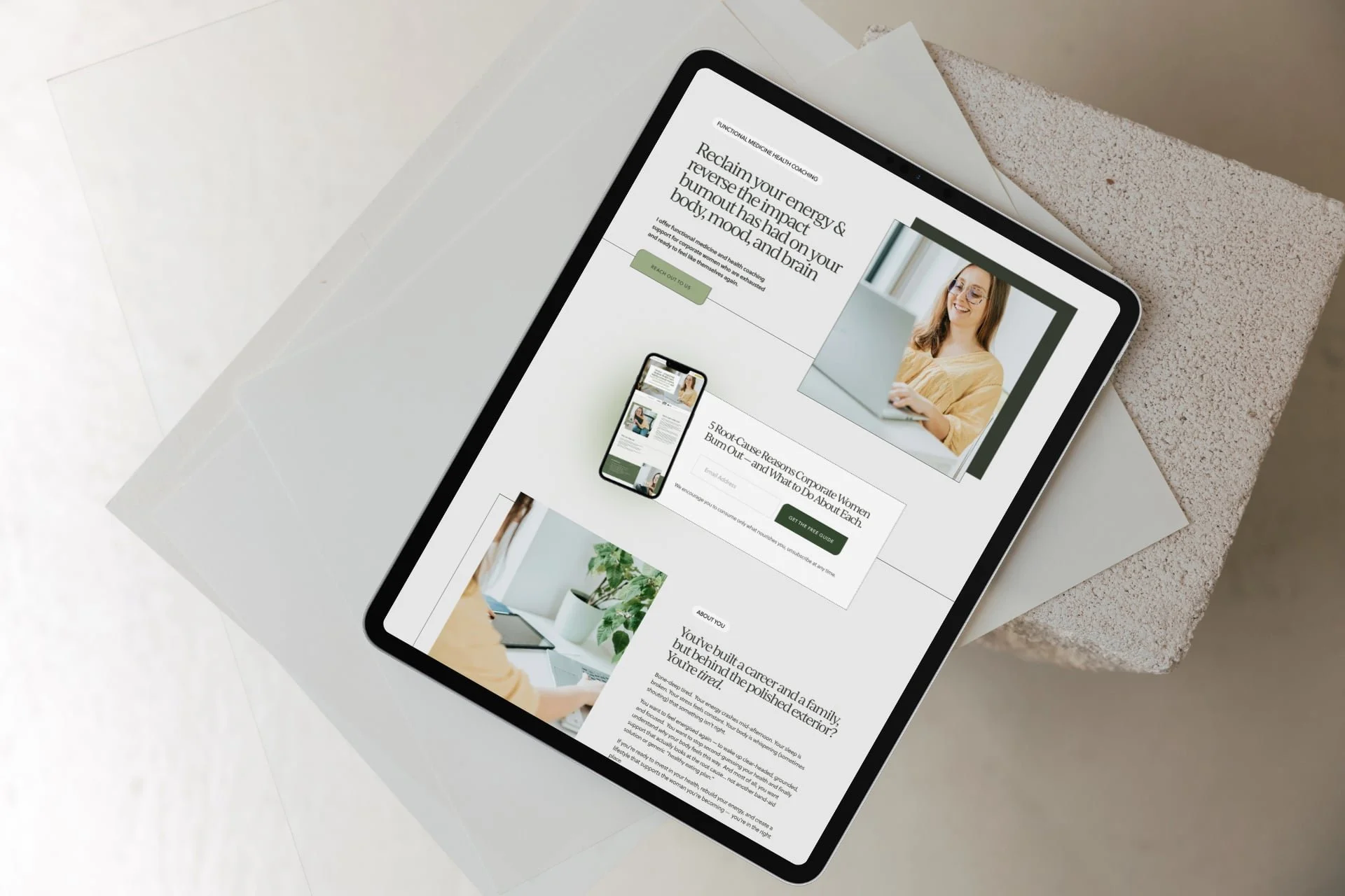 Tablet displaying a Health Coach Website Design with a smiling woman and text, with a fresh green and white colour palette, placed on a light-colored textured surface.