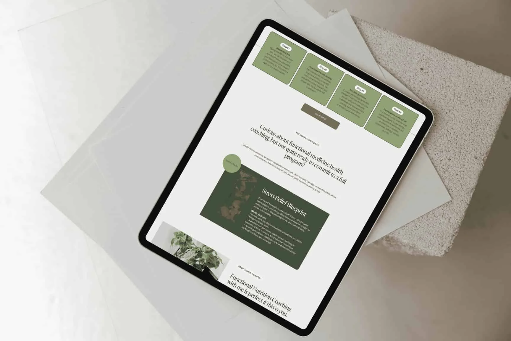 A smartphone on a light surface displays a health and wellness website design with images and text blocks in a minimalist layout.