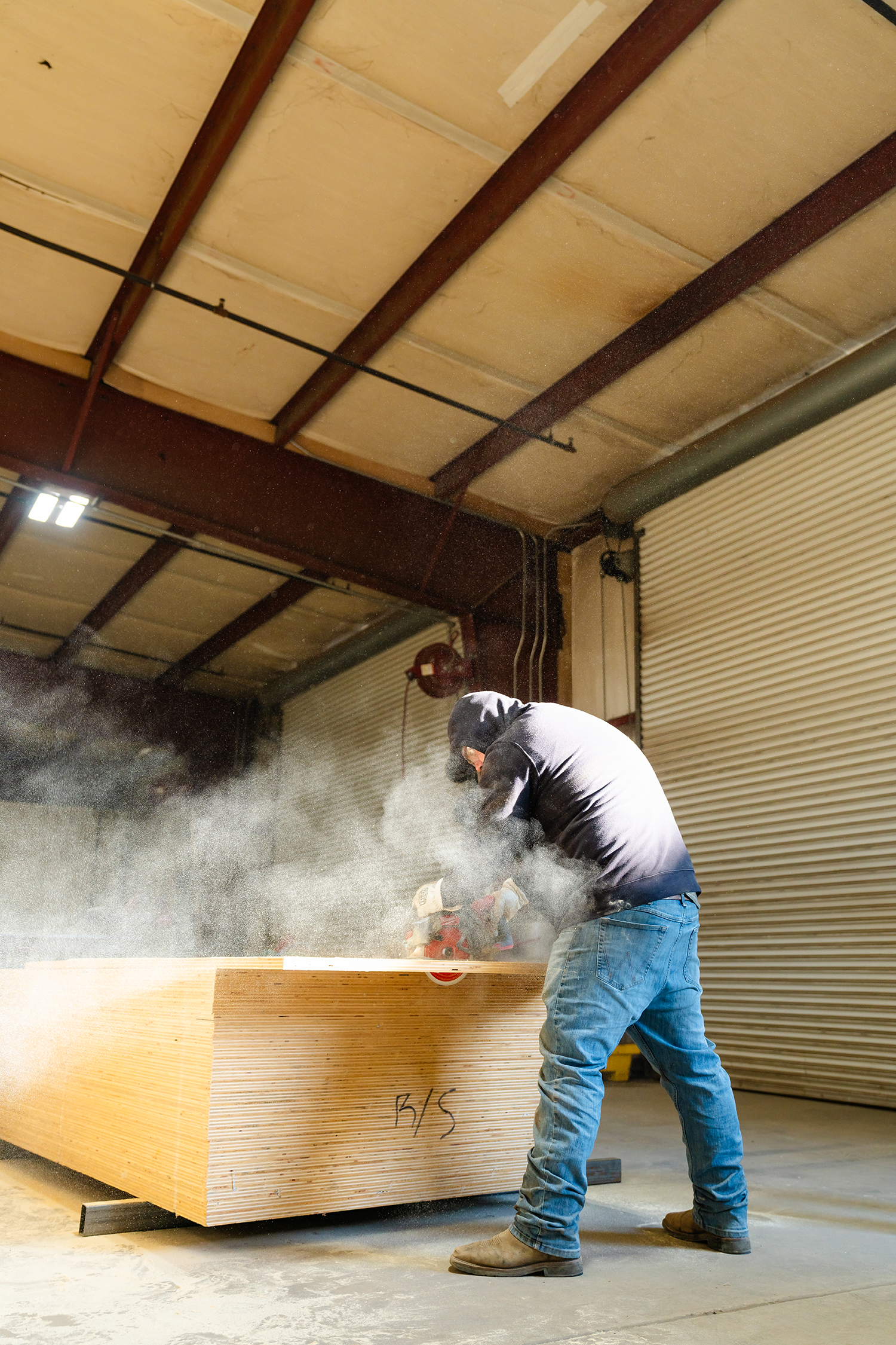 Man cuts through wood in a shop