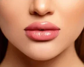 Close-up of a woman's lips and part of her nose with smooth skin and glossy lips.