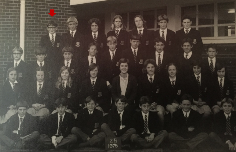 A black and white school class photo from 1975 of students in uniforms, with one teacher in the center, labeled 2B.