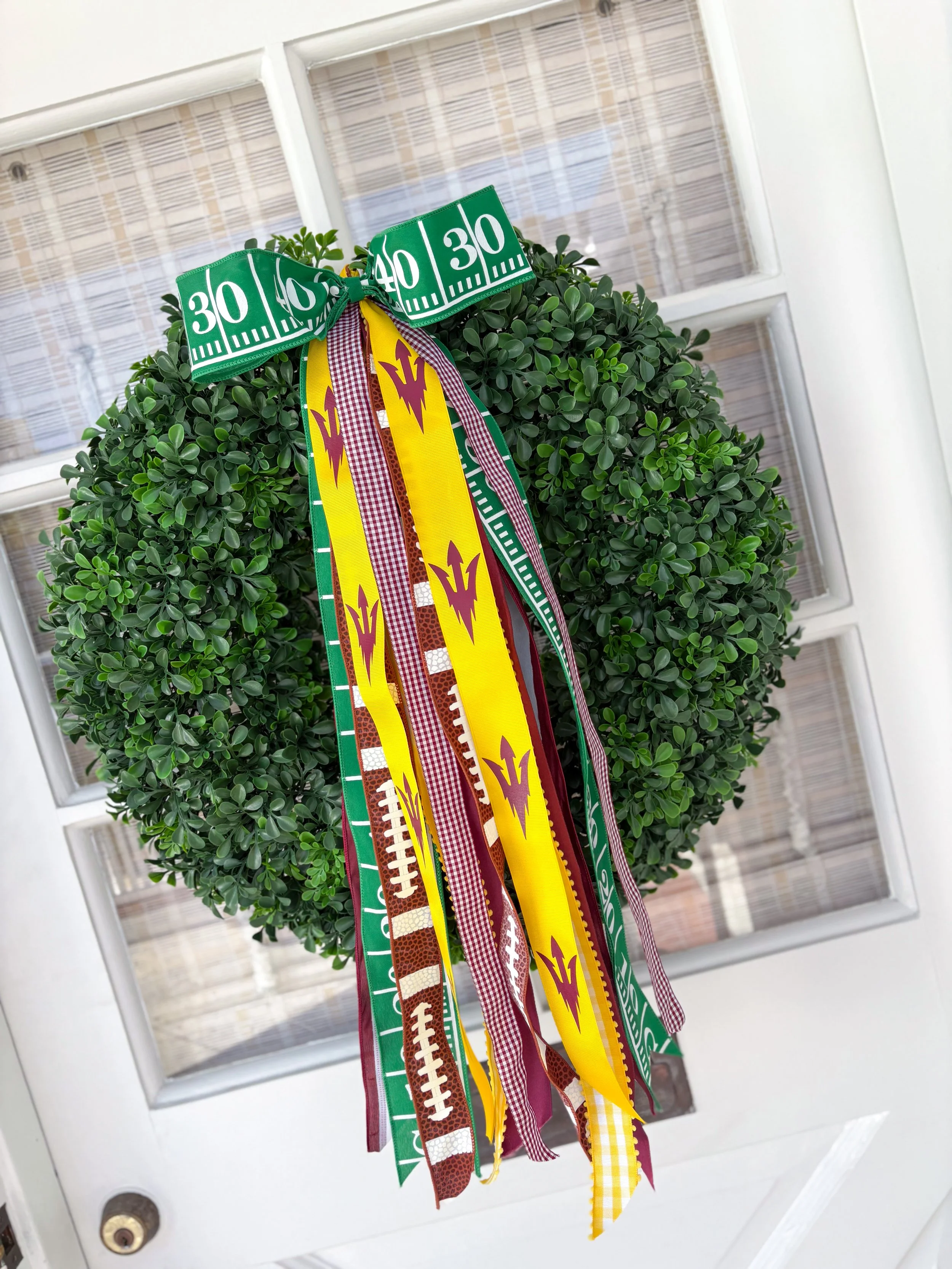 Decorative wreath on a door with colorful Arizona ribbons and a green football yard line bow.