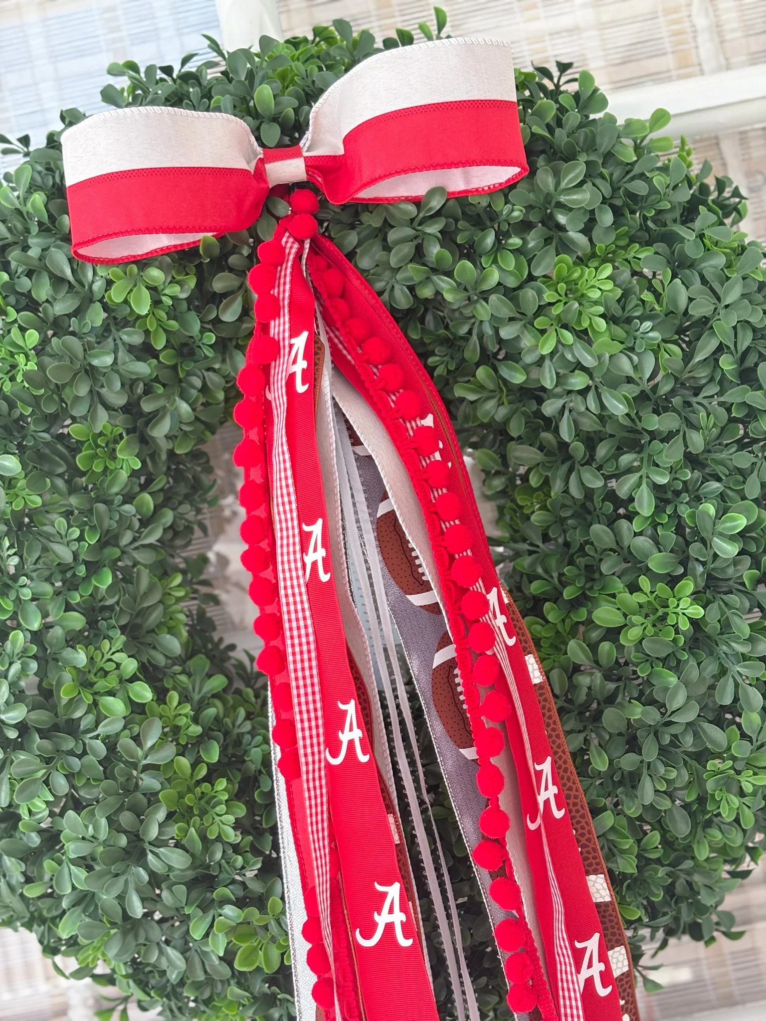 Ribbon wreath bundle with a red, white, and gray ribbon with the University letter 'A' on it, attached to a green boxwood wreath.