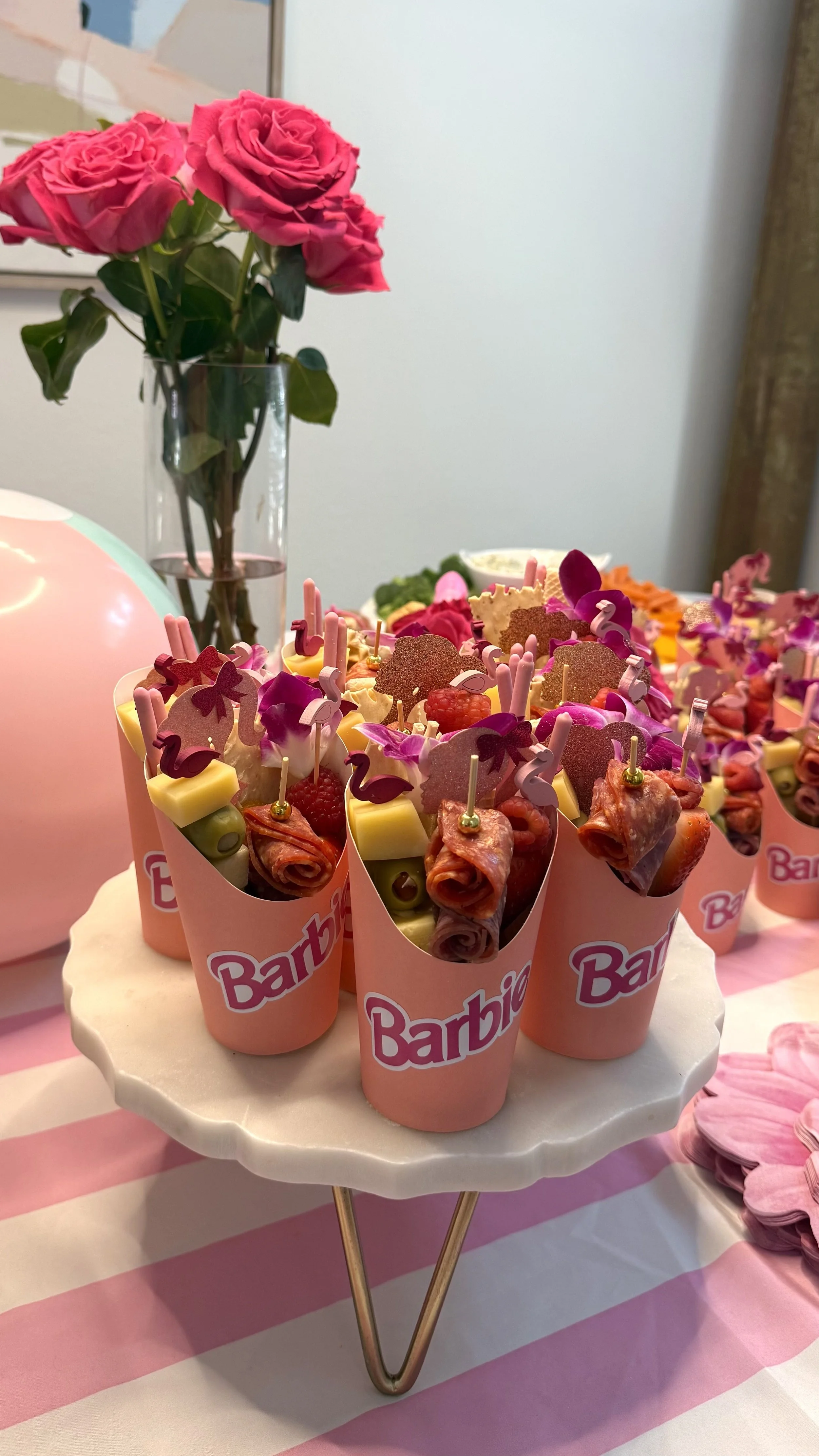 Barbie-themed individual charcuterie cups with cheeses, salami, fruit and olives, customized in pink for a themed celebration in San Antonio.