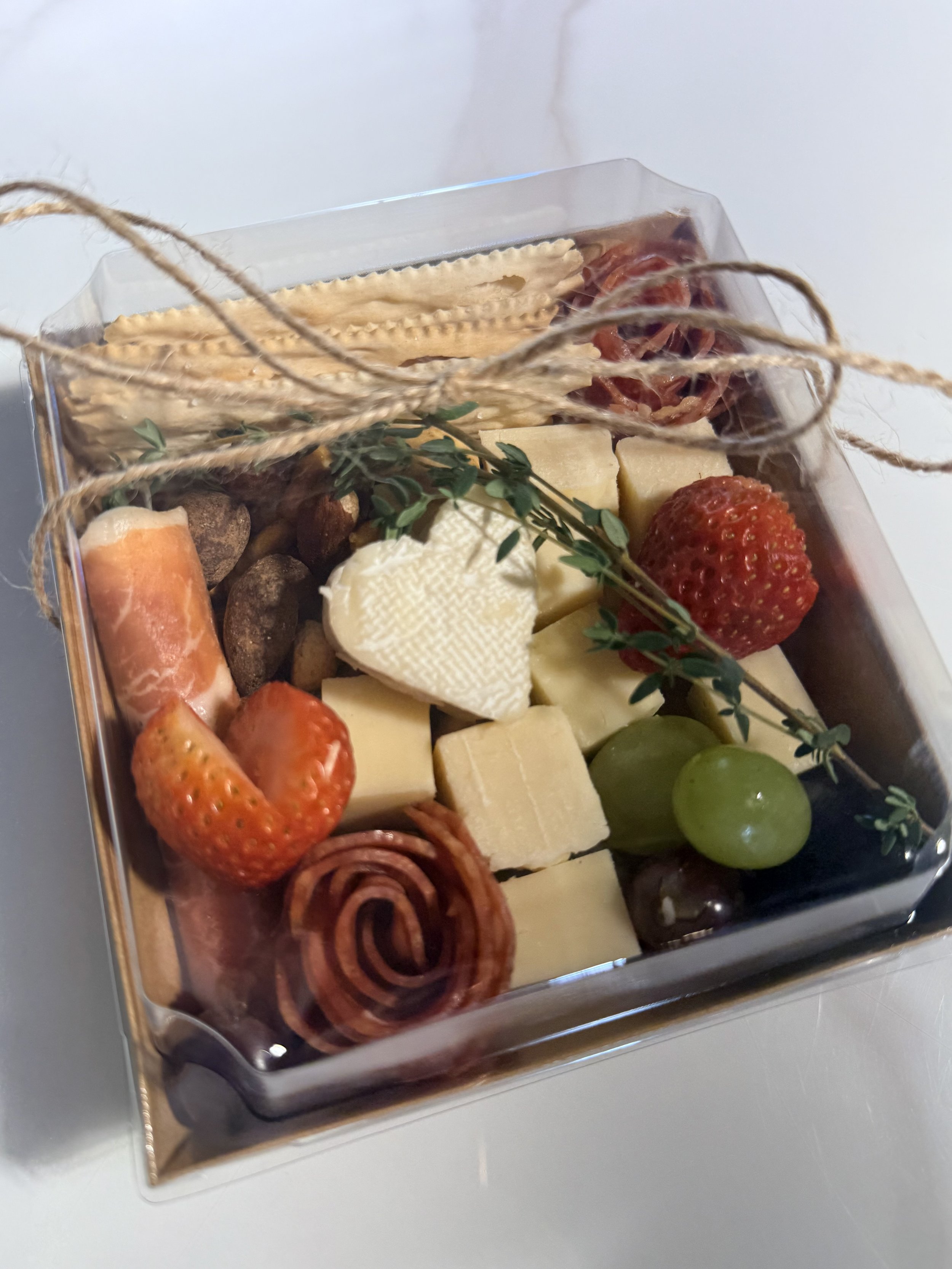 Individual charcuterie boxes with meats, cheeses, fruit, and crackers by Charcuterie Chic San Antonio