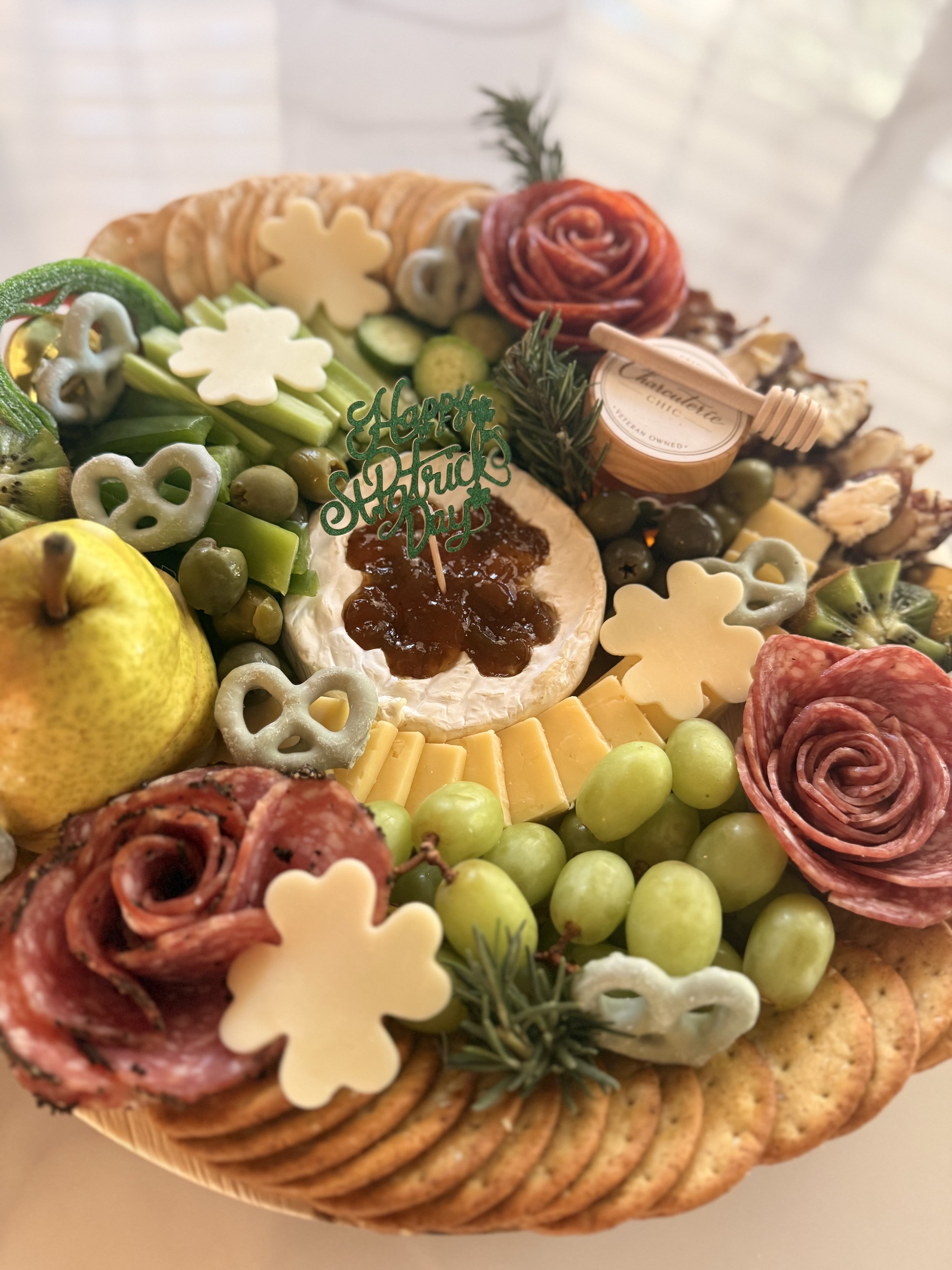 St. Patrick’s Day themed charcuterie board with shamrock cheese shapes, cured meats, fruit, and crackers by Charcuterie Chic San Antonio