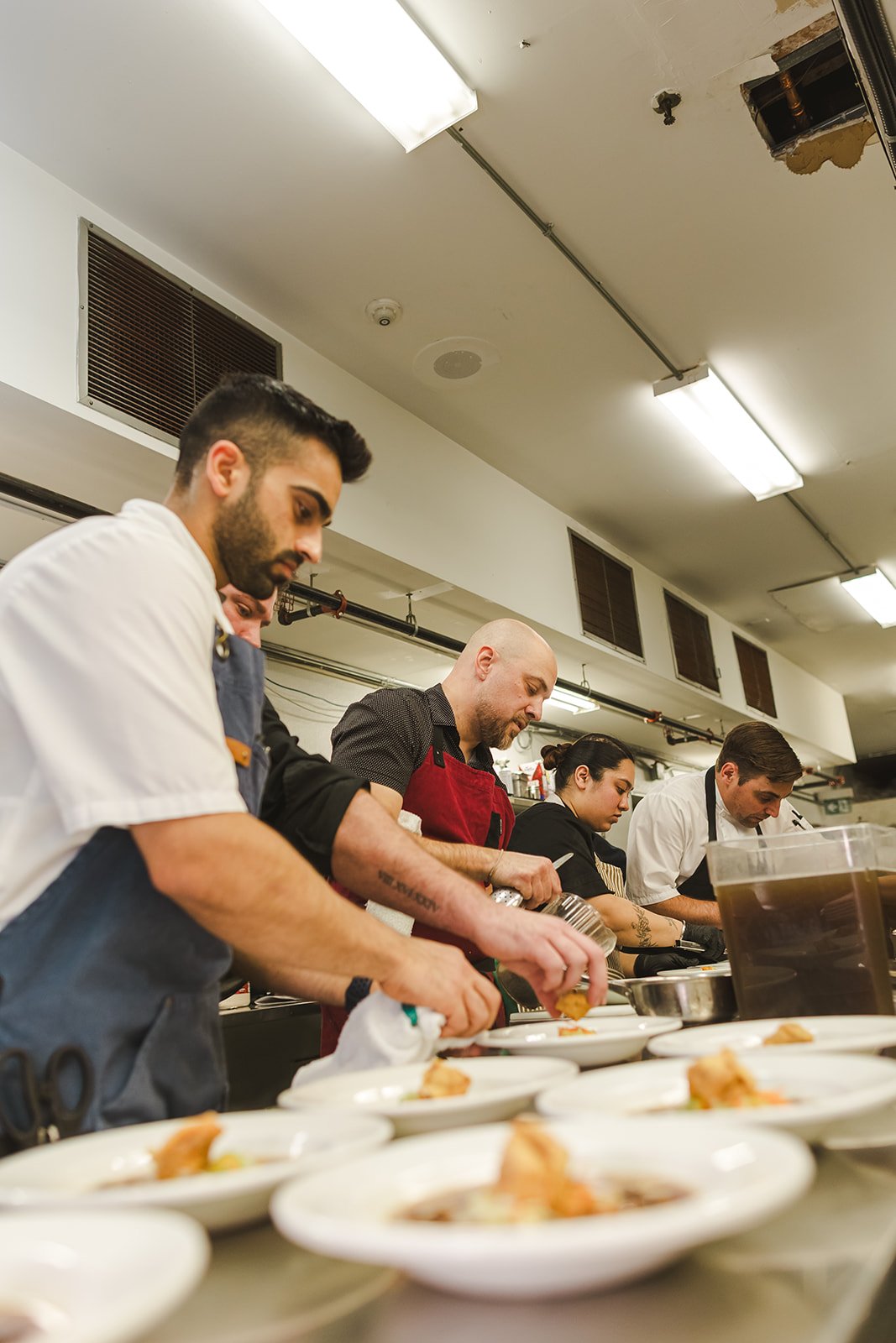 Group of chefs preparing dishes in a professional kitchen.