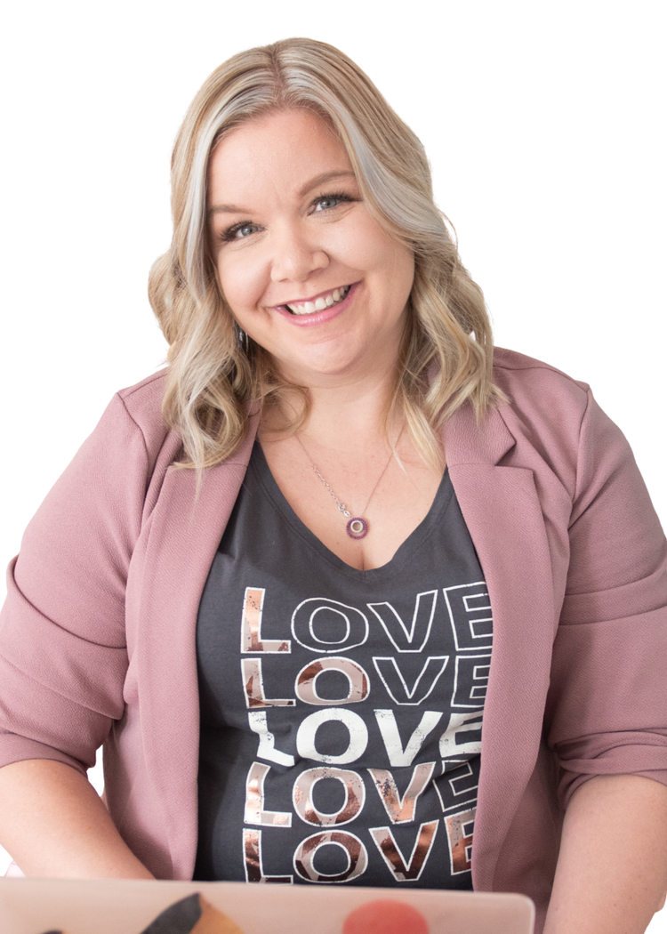 A woman with blonde hair smiling, wearing a pink blazer over a black T-shirt with the word 'LOVE' repeated in different styles, and a necklace with a circular pendant.