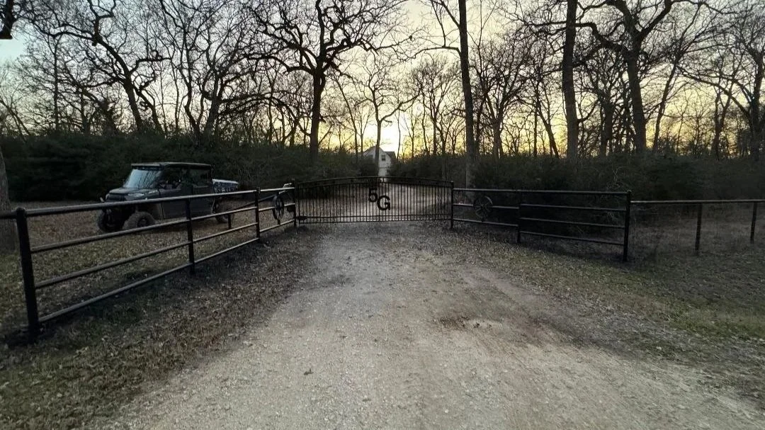 This custom 16' entrance gate features a simple, timeless design that complements its surroundings. Its sturdy construction ensures dependable performance and ease of use.