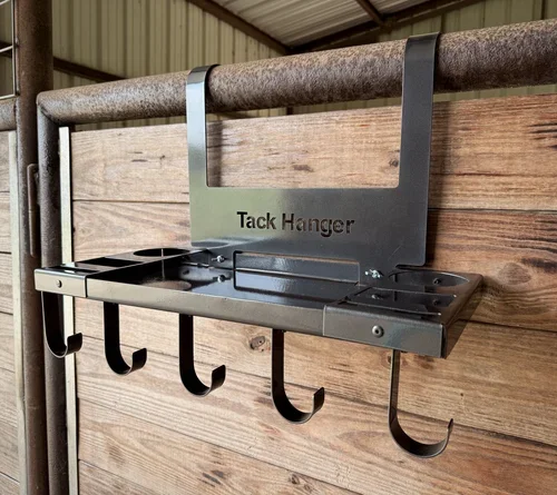 A Tack Hanger mounted on a wooden wall with five hooks for organizing tools or accessories.