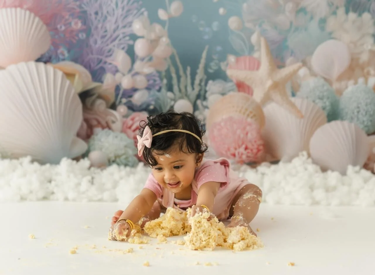 Baby covered in cake during Christchurch cake smash milestone session with Eastwood Studios