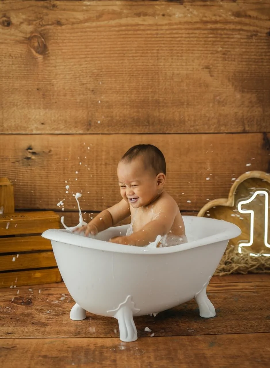 Joyful baby boy in vintage bath capturing first birthday Bishopdale