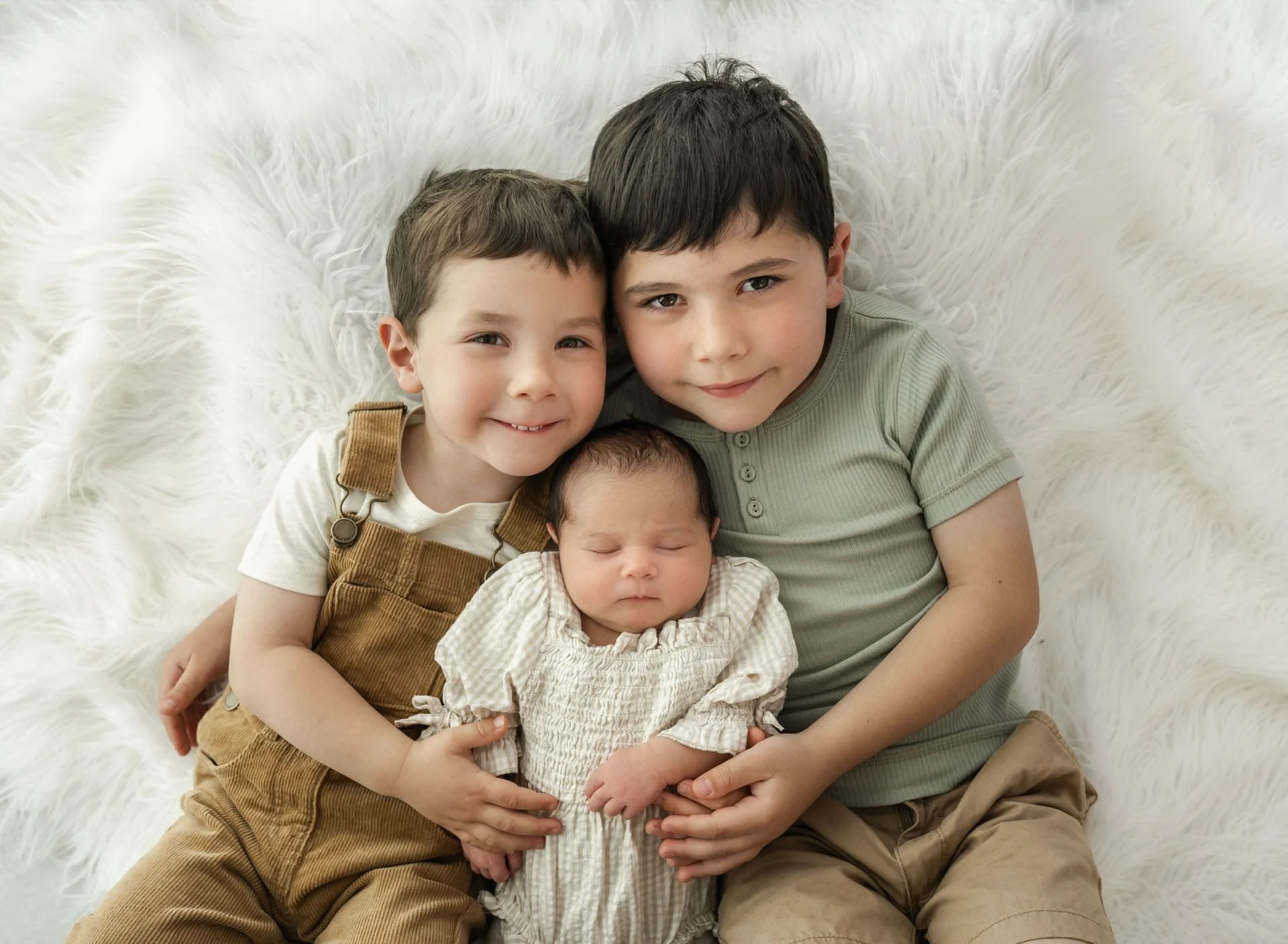 Siblings holding new baby sister during Christchurch newborn All Loved Up photography session
