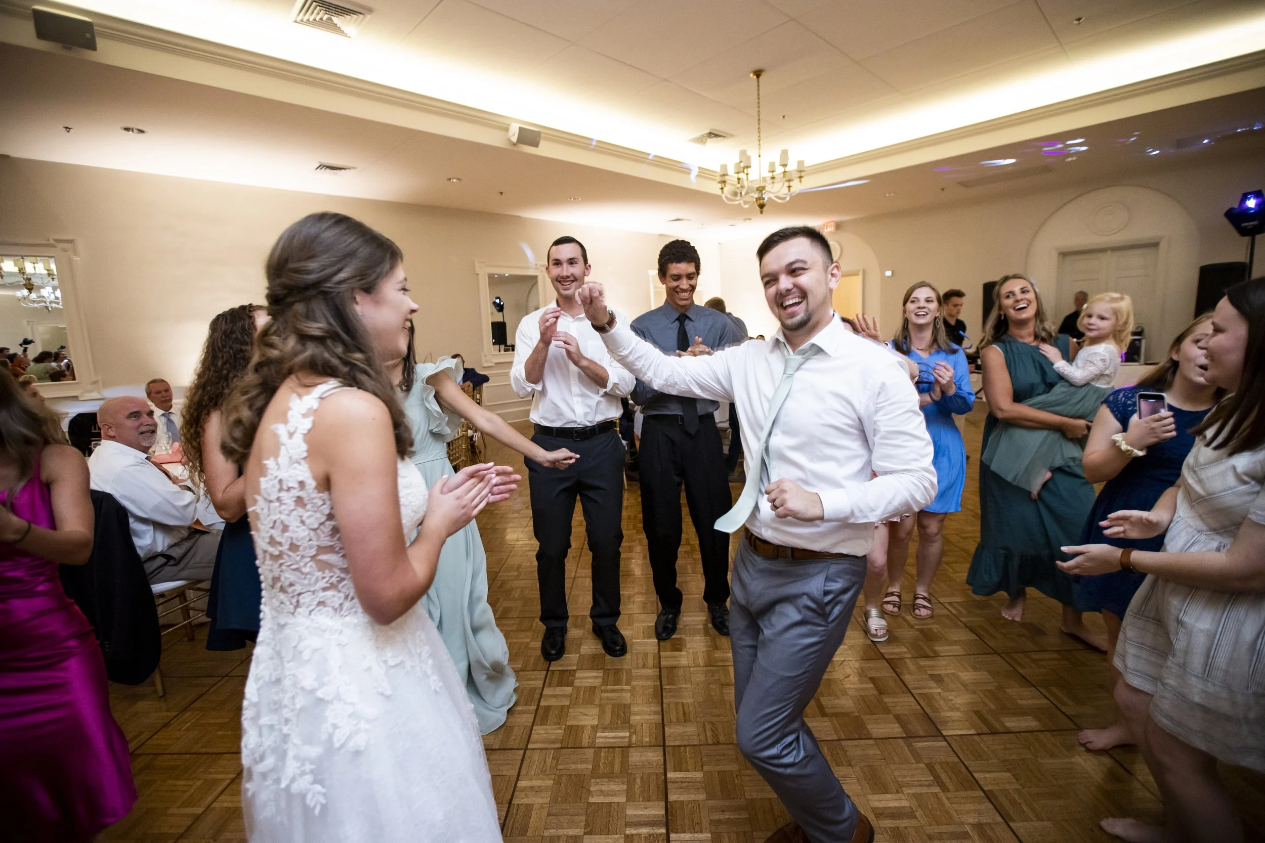 People dancing and celebrating at a wedding reception in a ballroom
