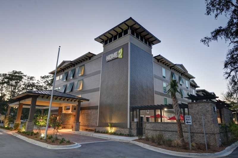 Exterior view of a modern multi-story hotel building with a sign displaying 'HOME2'.