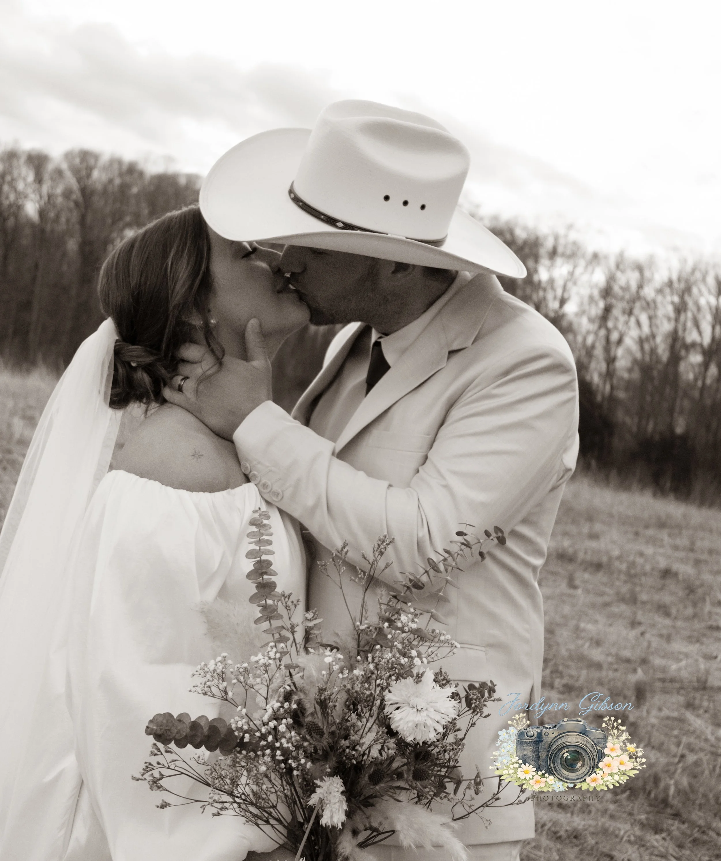 Couple standing in a field with a veil in a white dress. Elopement Photography Sophia NC