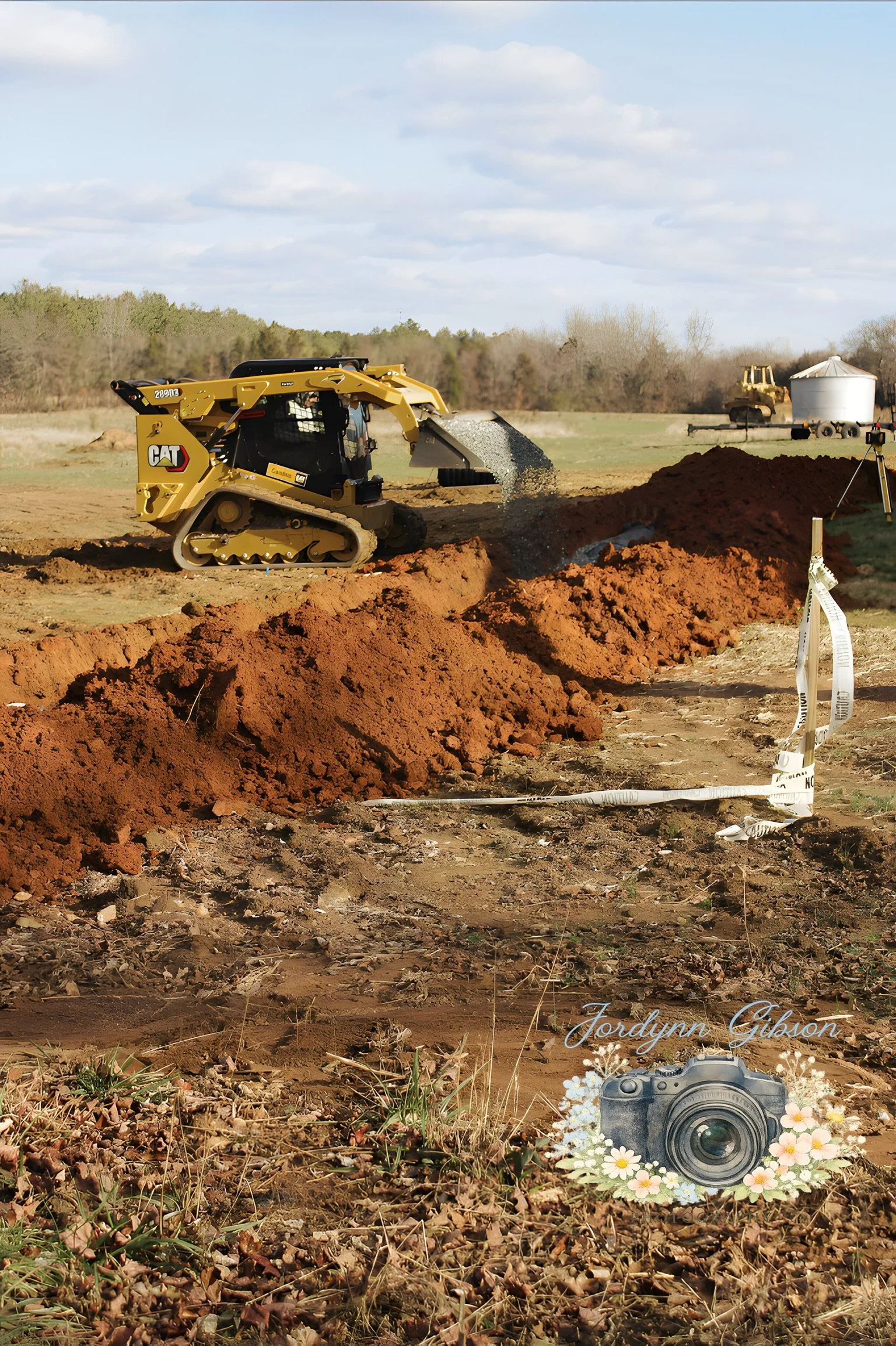 A construction site with a yellow bulldozer spreading dirt in a field. In the foreground, there is a digital illustration of a camera with the name Jordynn Gibson surrounded by flowers. A white ribbon is on the ground, and there is a surveyor tripod 