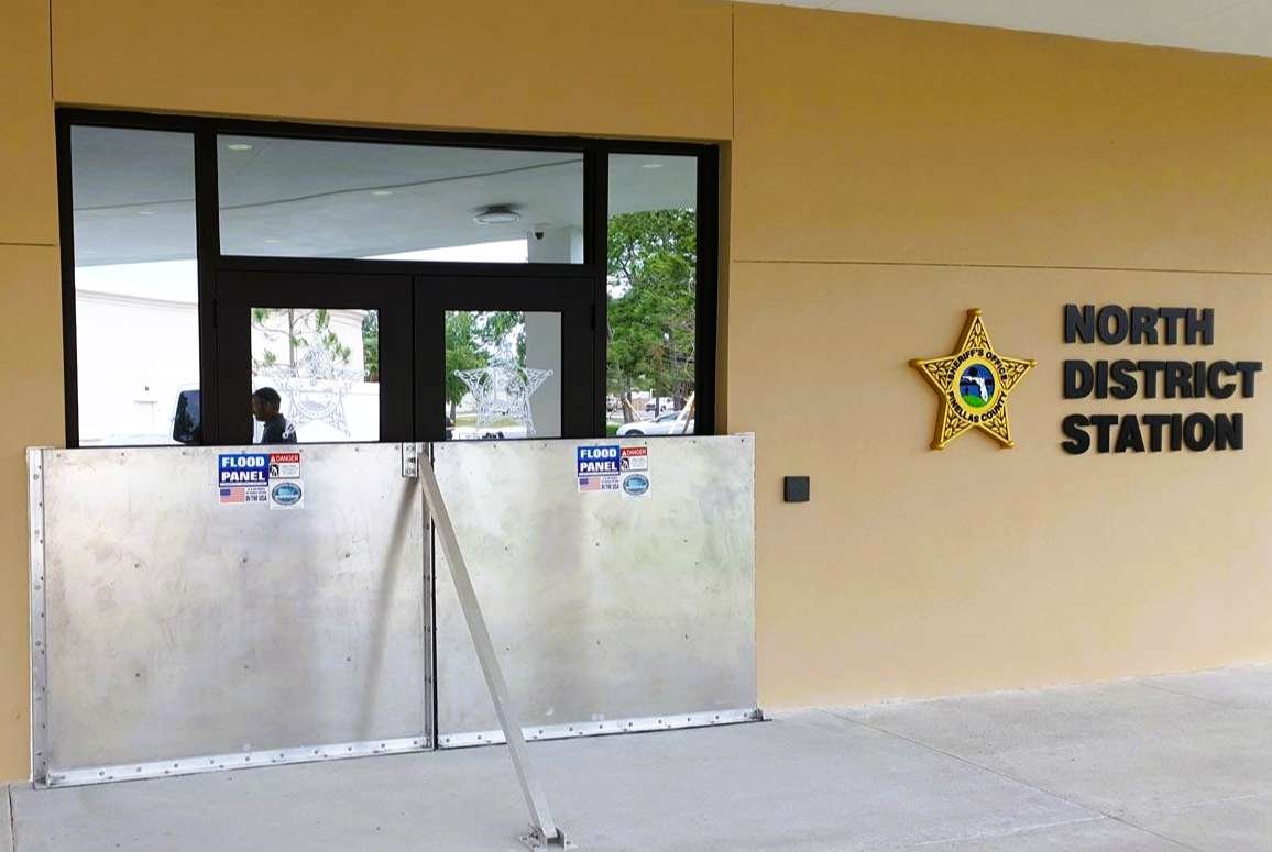 Public safety facility with deployable flood barriers installed to protect emergency response infrastructure