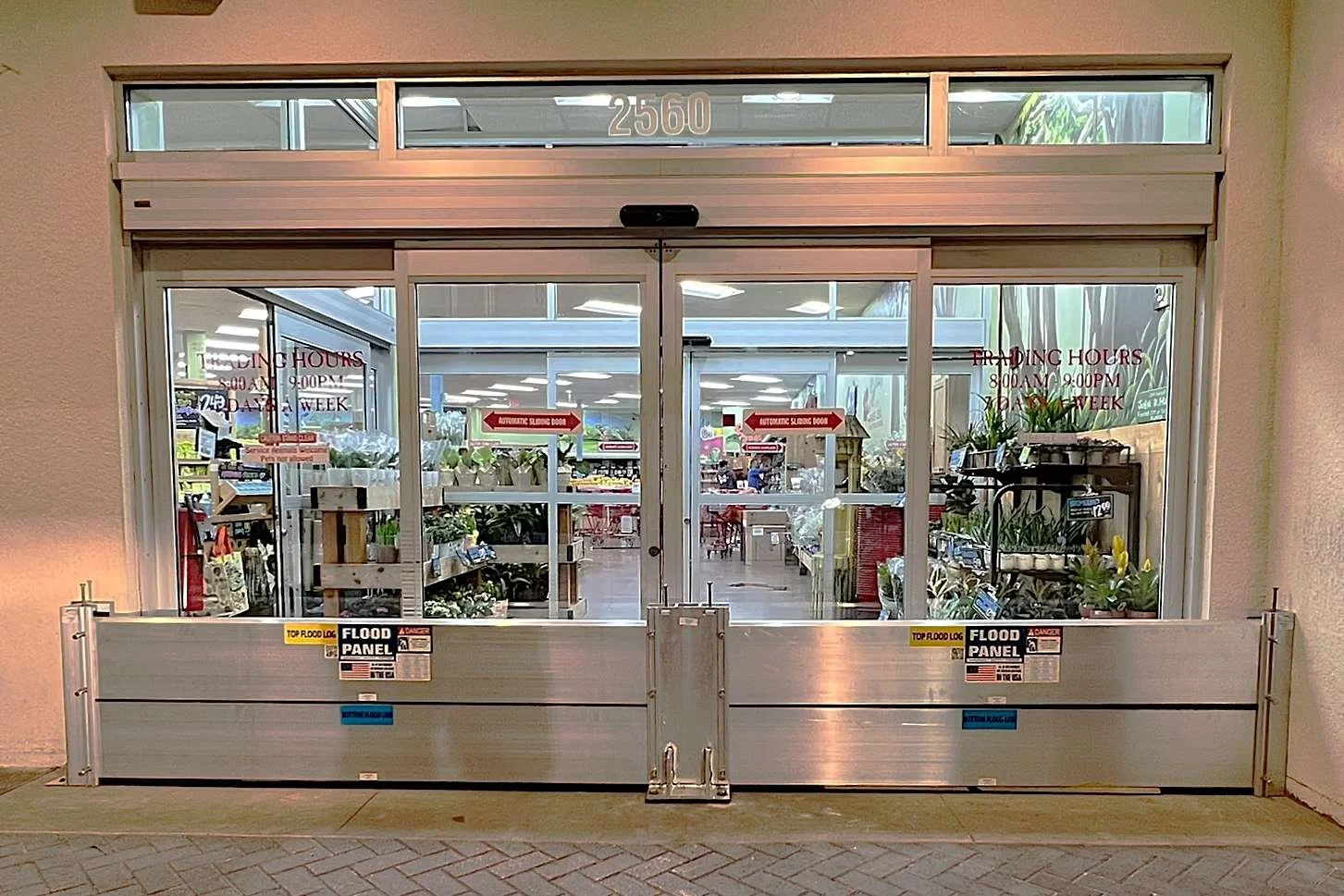 Commercial retail entrance protected by deployable flood barrier system for business continuity during storm surge events