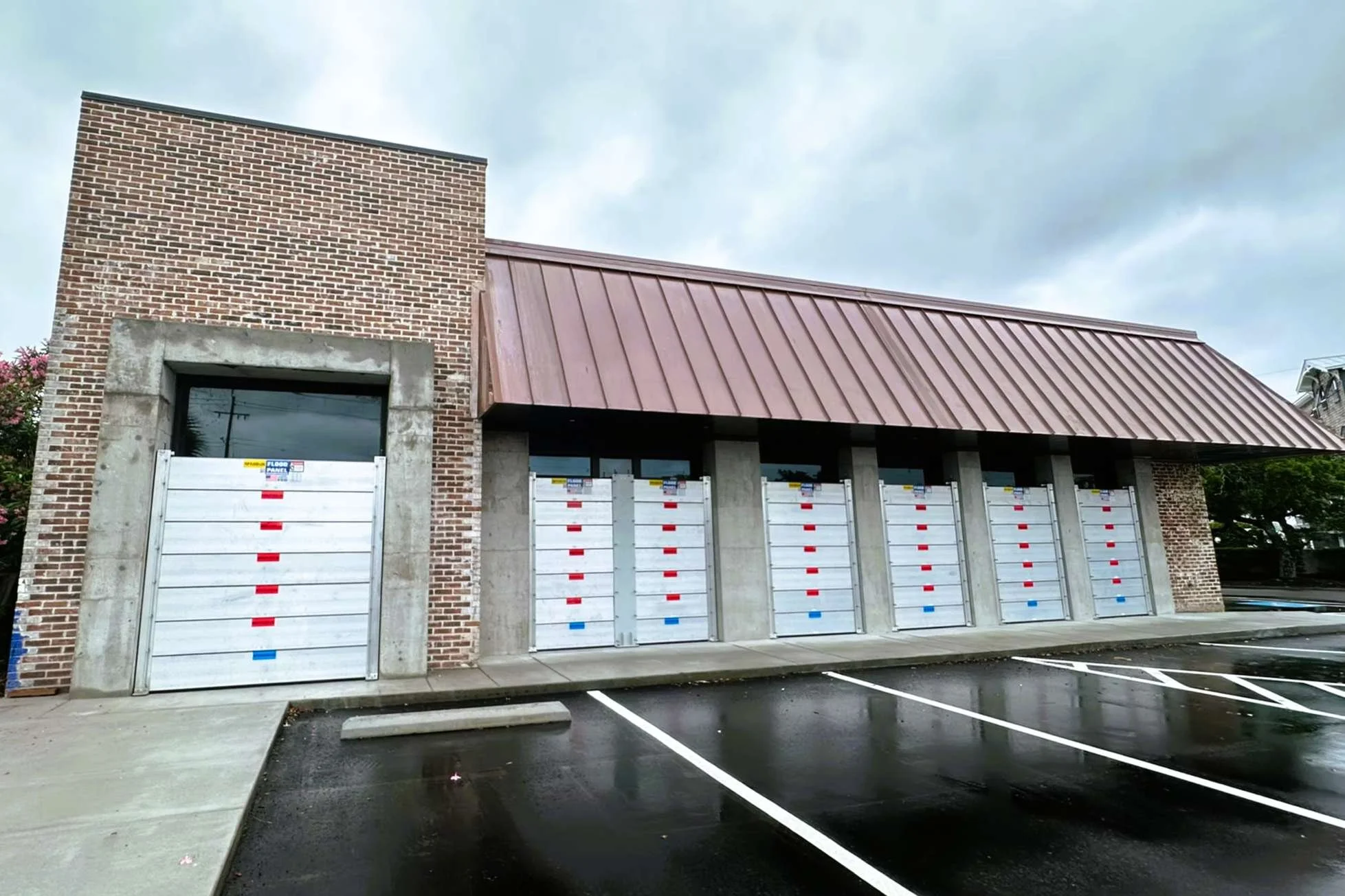 Hospitality facility with deployable flood barrier systems installed to protect guest areas and operational assets