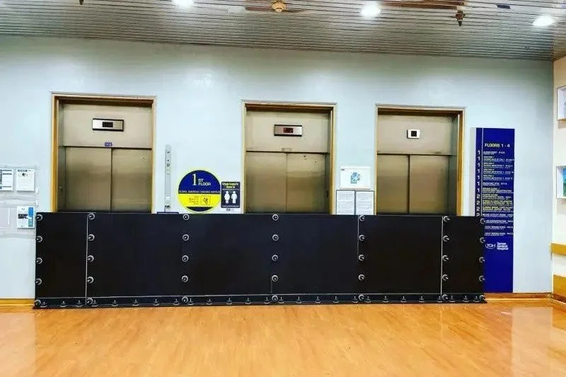 Black deployable flood barrier system installed across multiple interior door openings.