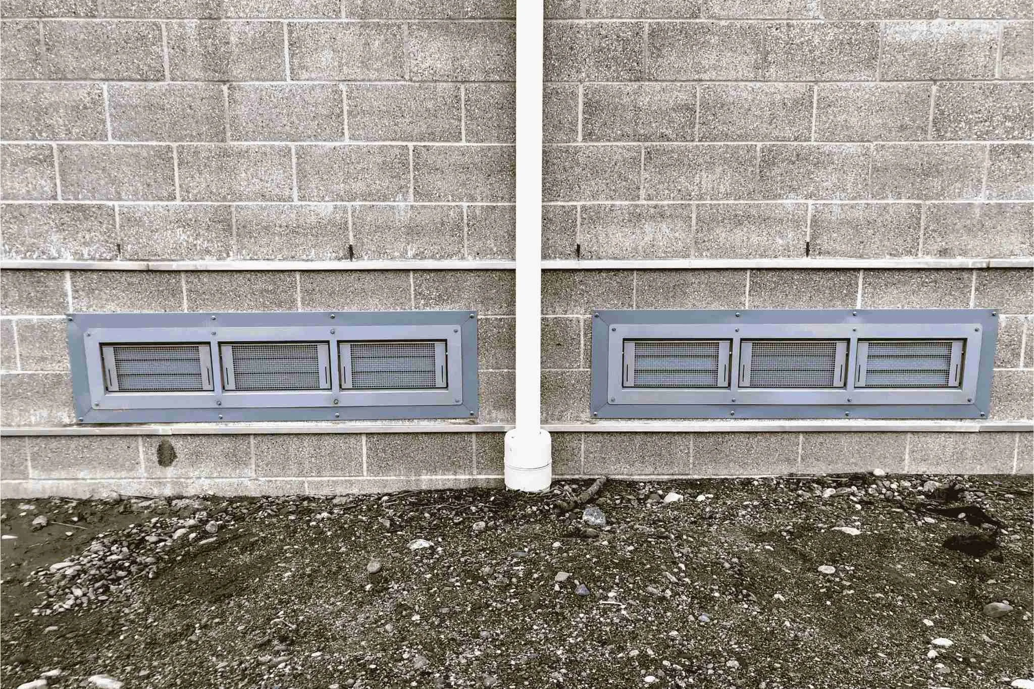 Insulated flood vents installed in masonry foundation wall for compliant floodwater equalization in enclosed structure
