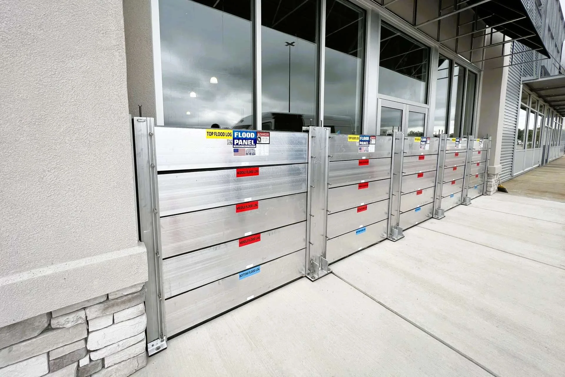 Continuous deployable flood barrier system installed along commercial building frontage for perimeter protection.