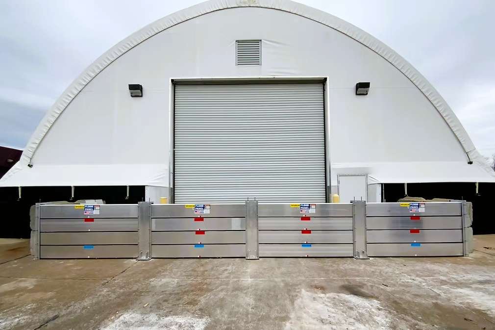 Industrial warehouse facility protected by engineered flood barriers to safeguard equipment and maintain production continuity