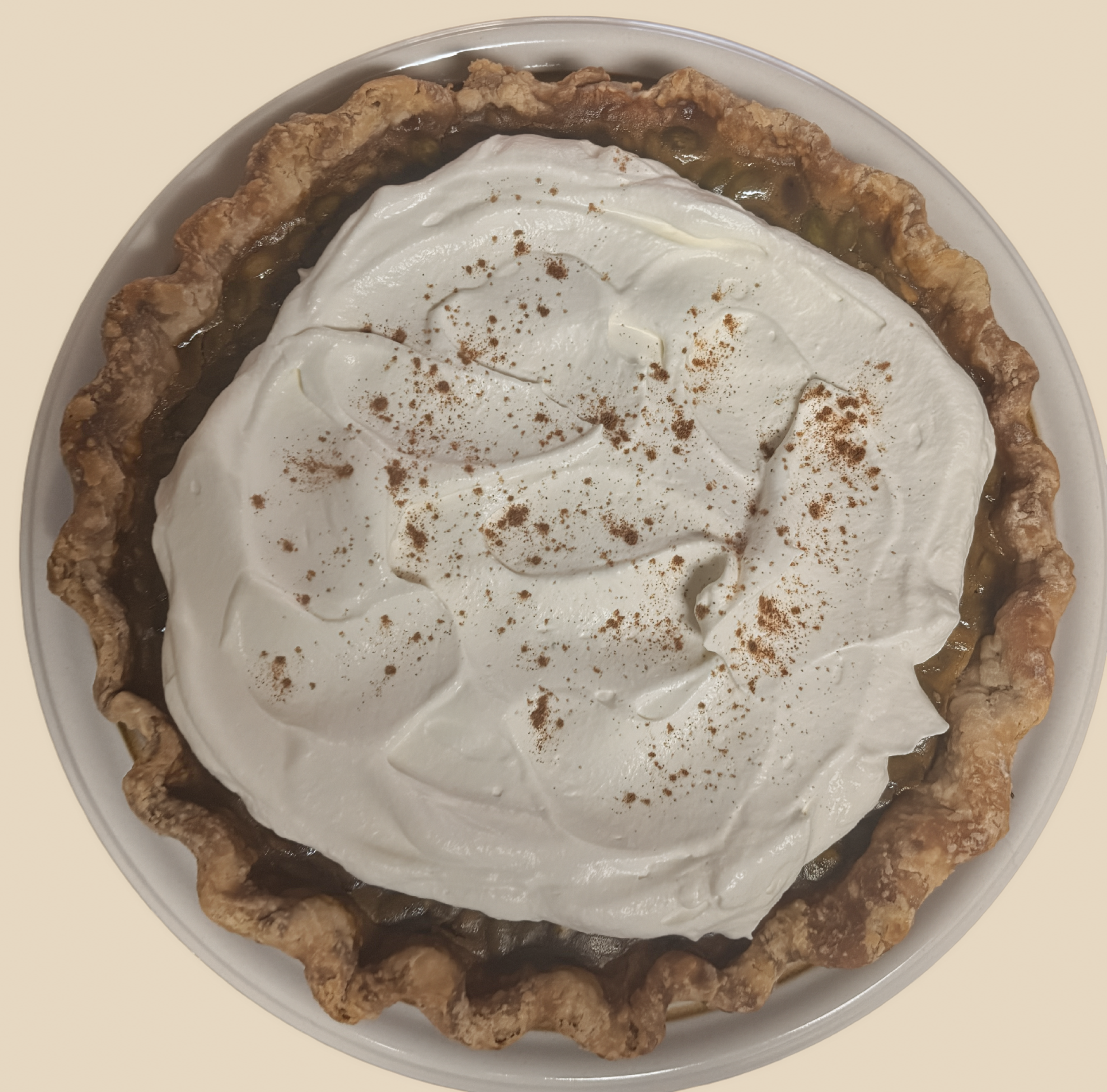Pumpkin pie with pepitas topped with whipped cream w/pumpkin spice sprinkled. 