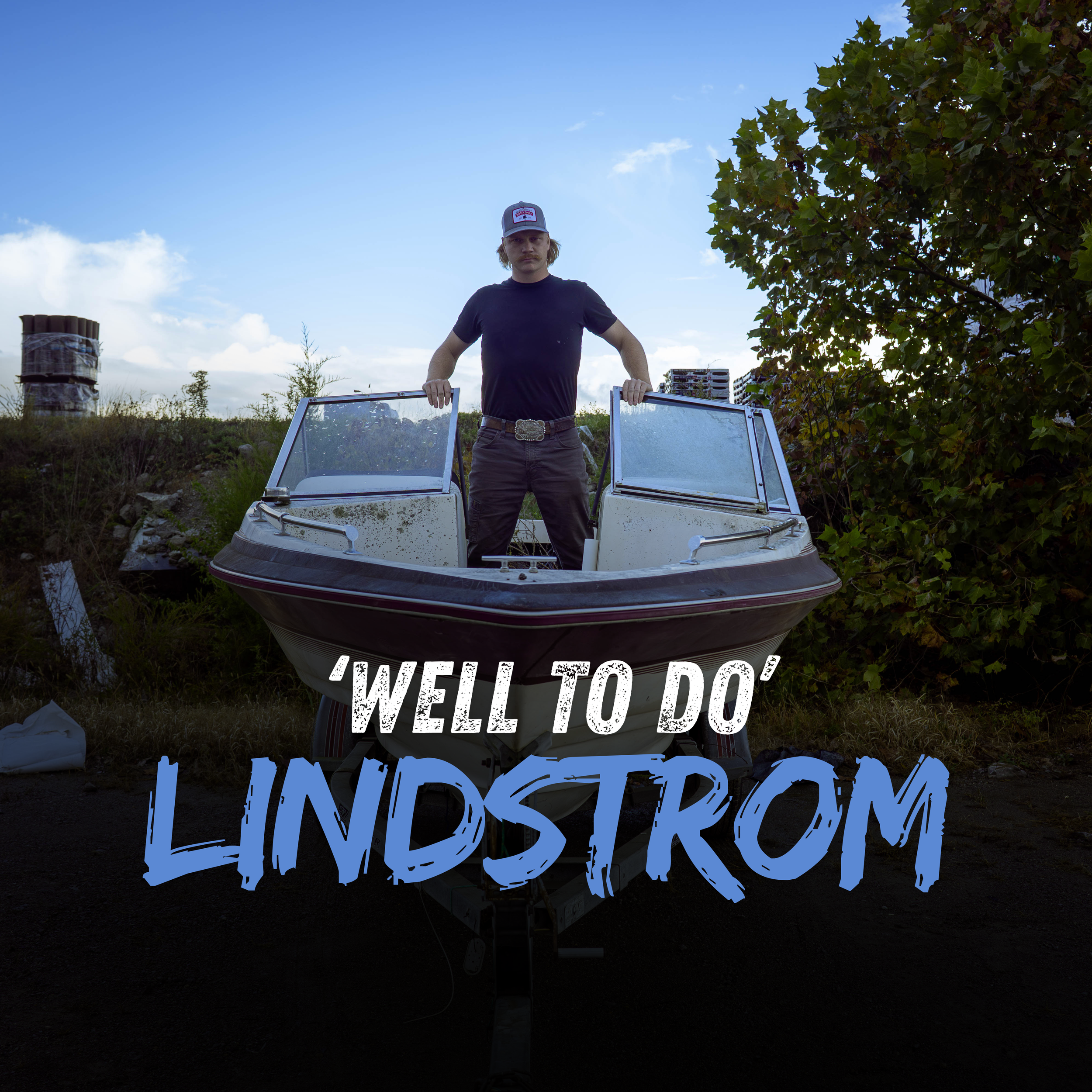 A young man stands confidently on a boat with a background of blue sky, bushes, and trees. The boat is on land, and the man is holding onto the boat's windshield frames. The text on the image reads, 'WELL TO DO' LINDSTROM.