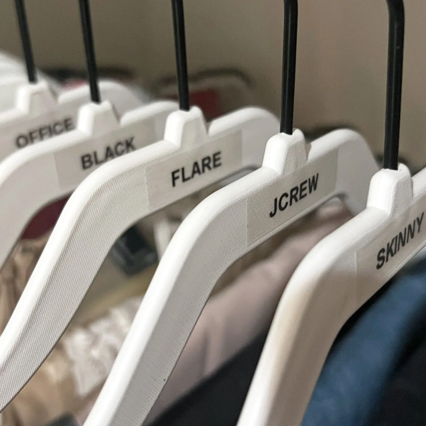 A photo from a closet organizing and stylist session shows clothing hangers labeled with different styles including OFFICE, BLACK, FLARE, JCREW, and SKINNY.
