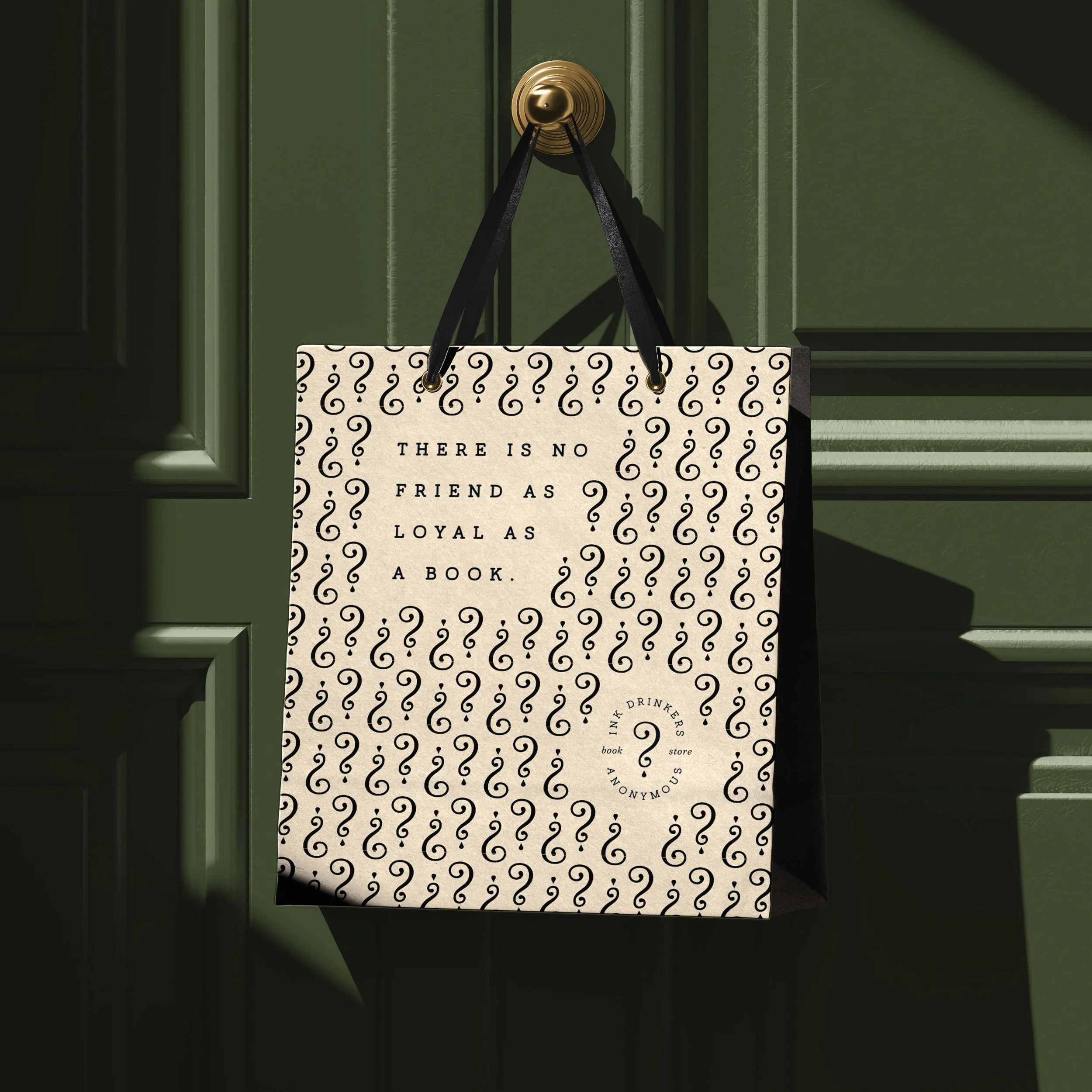 A green front door with a round brass doorknob. Hanging from the doorknob is a small black and white tote bag with question marks and a quote that says, 'There is no friend as loyal as a book.' The door has decorative molding.