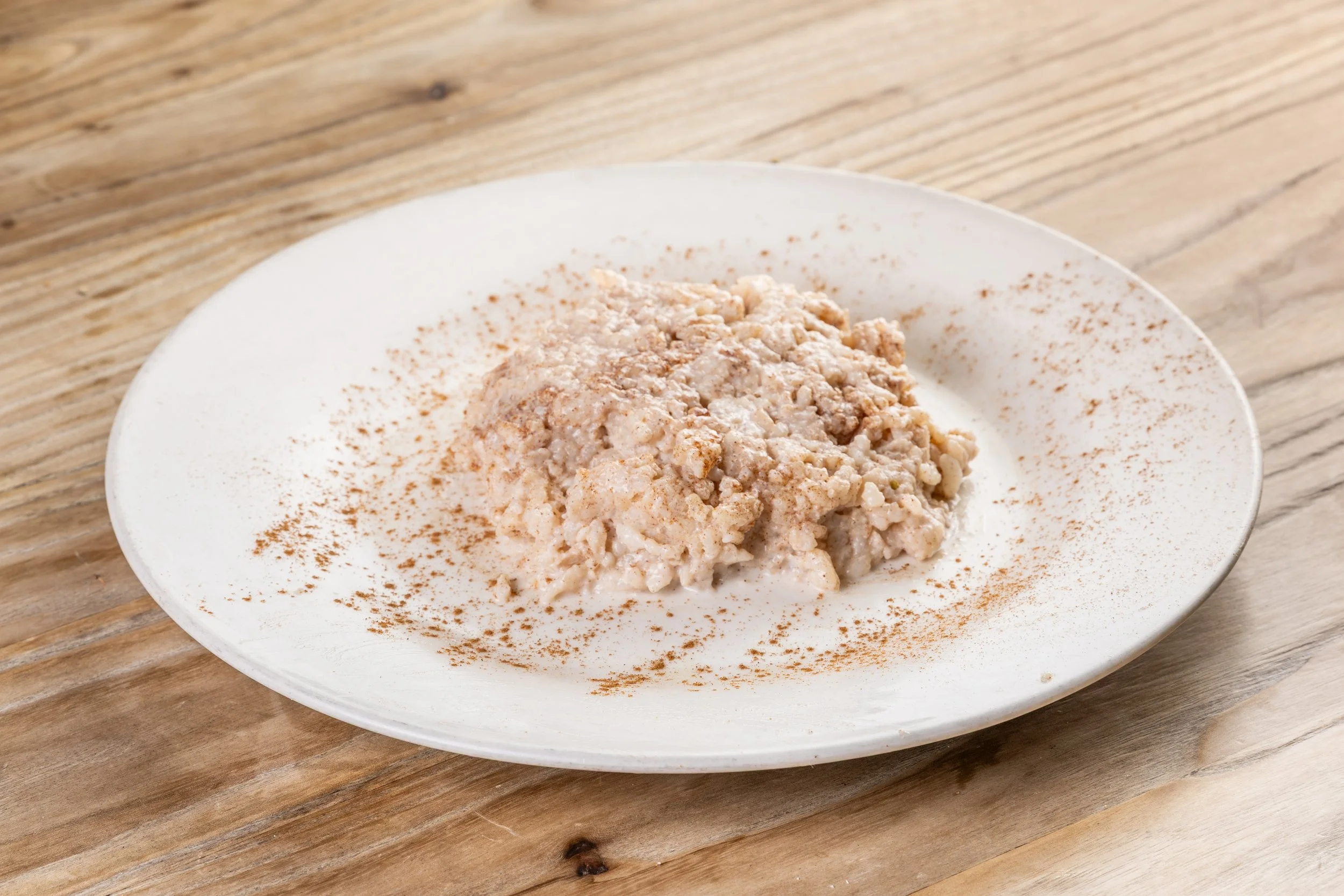 Rice pudding with cinnamon on a white plate