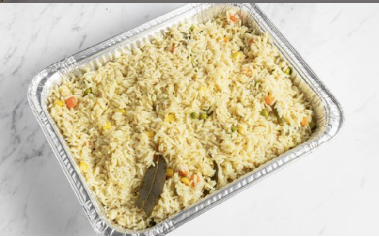 Tray of white rice with mixed vegetables on a white surface.
