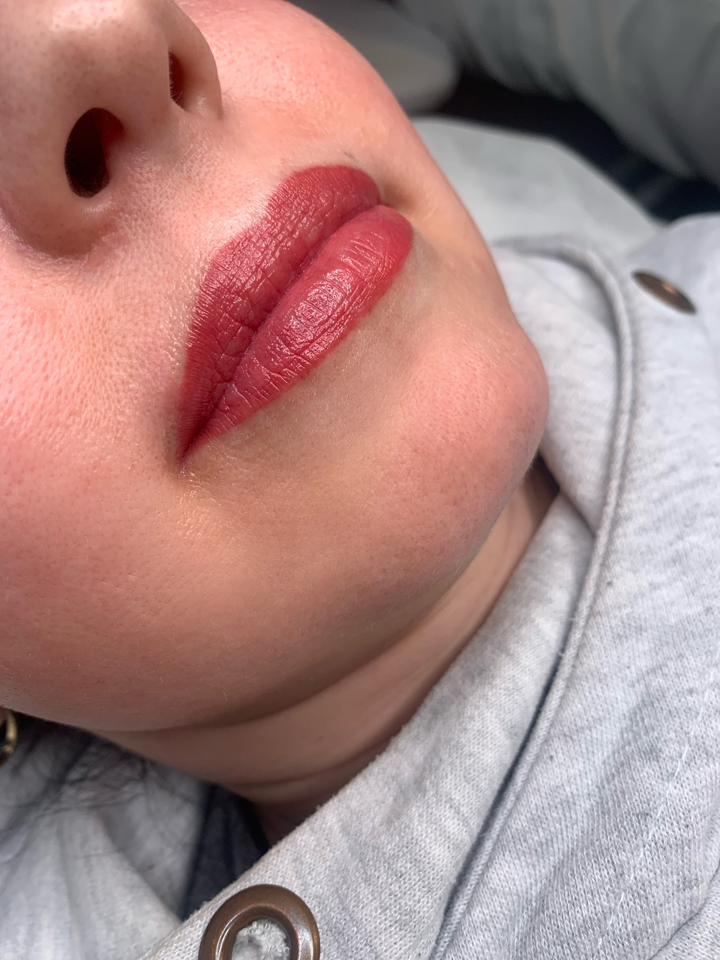 Lip blushing permanent makeup result with soft pink, naturally enhanced lips.