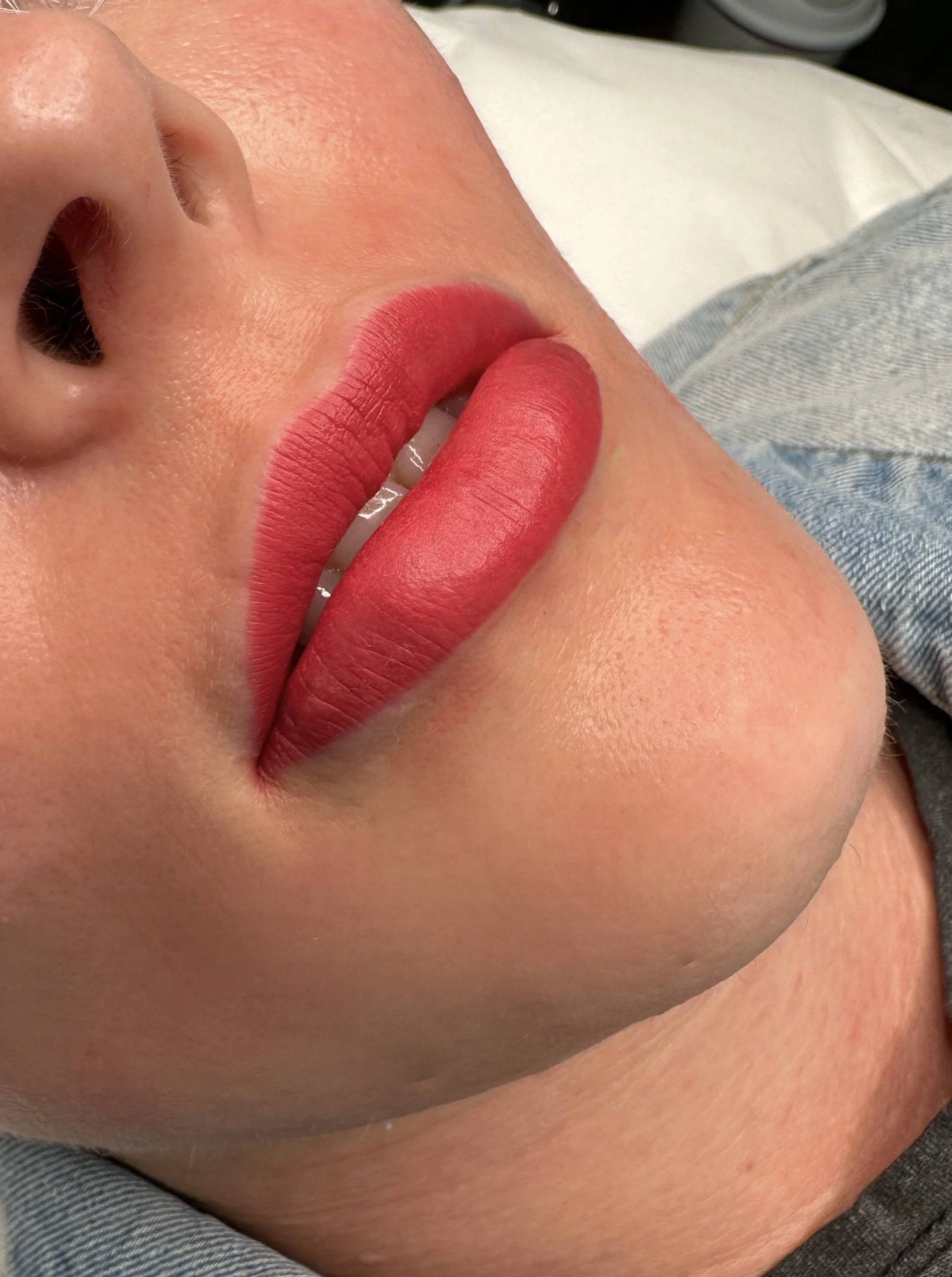 Lip blushing permanent makeup result with soft pink, naturally enhanced lips.