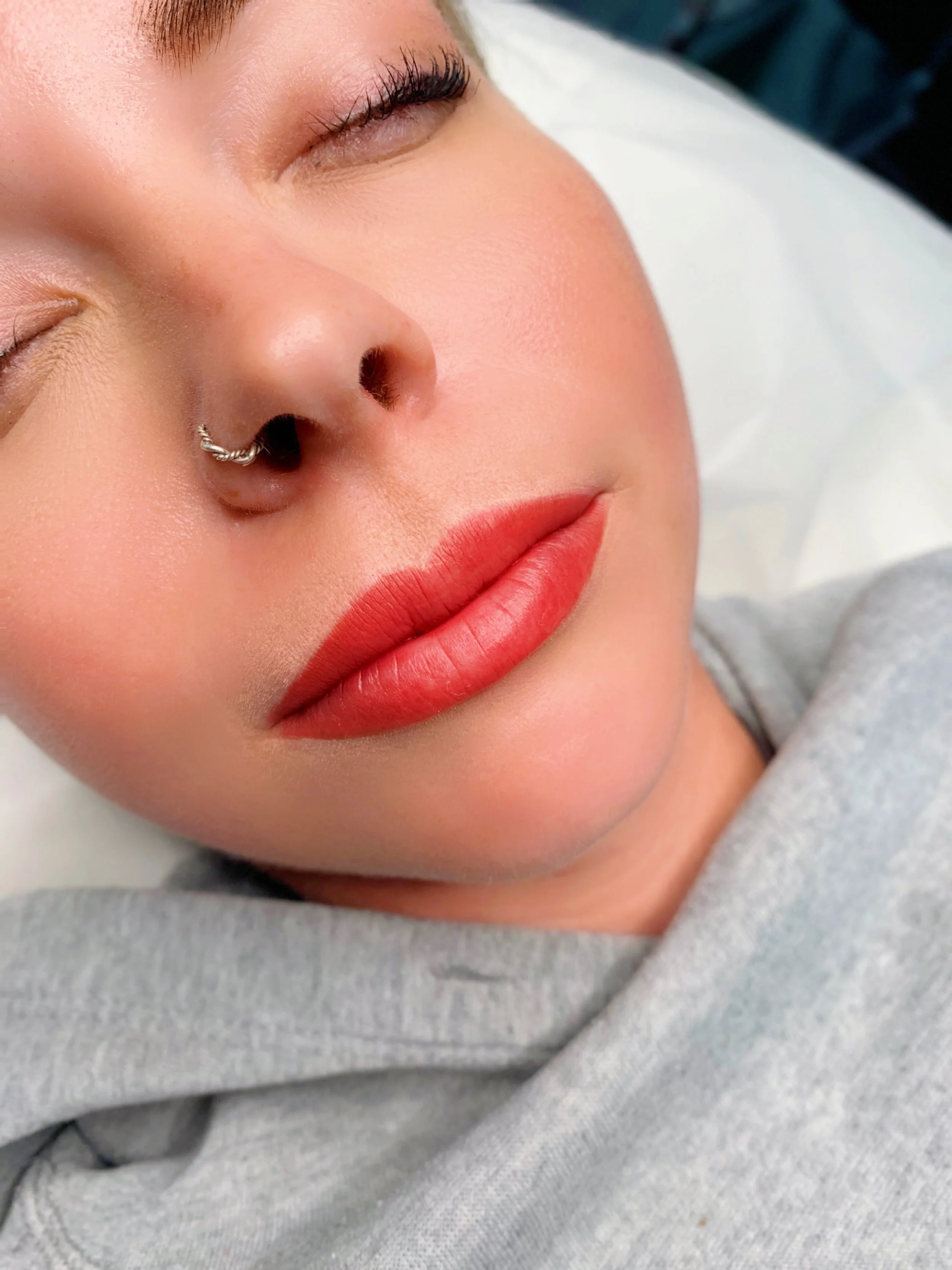 Lip blushing permanent makeup result with soft pink, naturally enhanced lips.