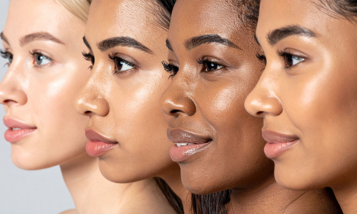 Close-up side profile of four diverse women with clear skin, showcasing natural beauty.