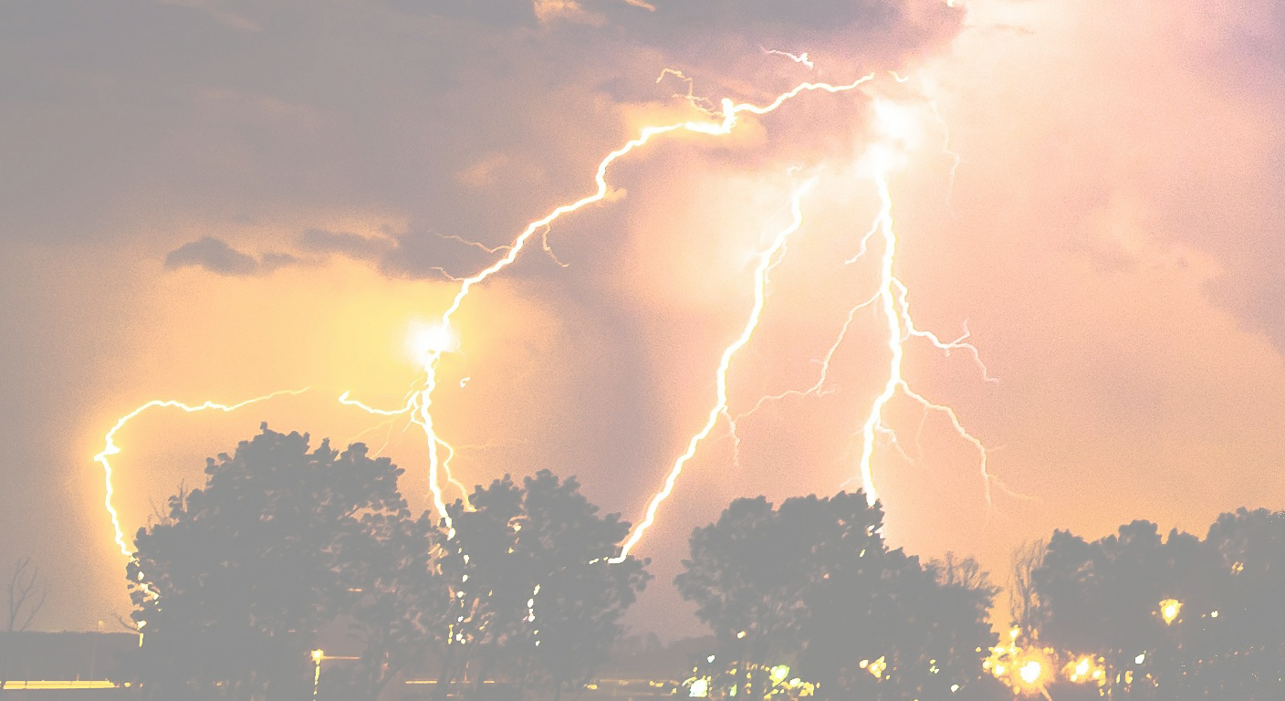 Lightning strikes during a thunderstorm above trees at dusk or night, illuminating the dark sky with bright, jagged flashes.
