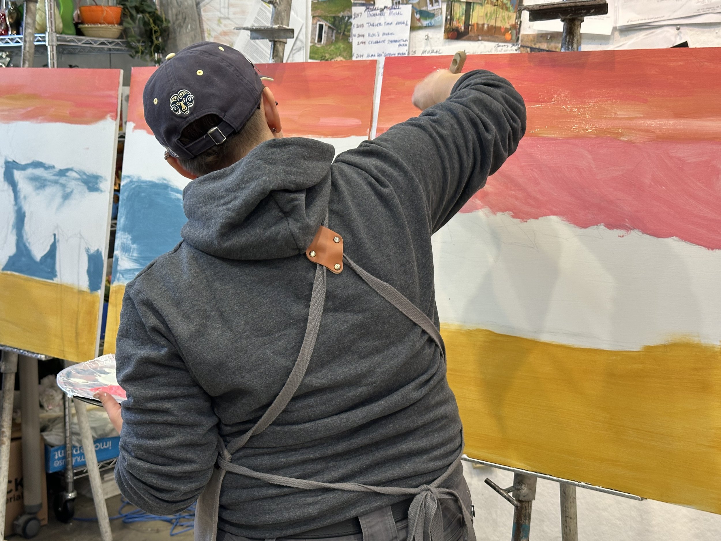 Team member, Kim Workman, taking turns working on the small mural.