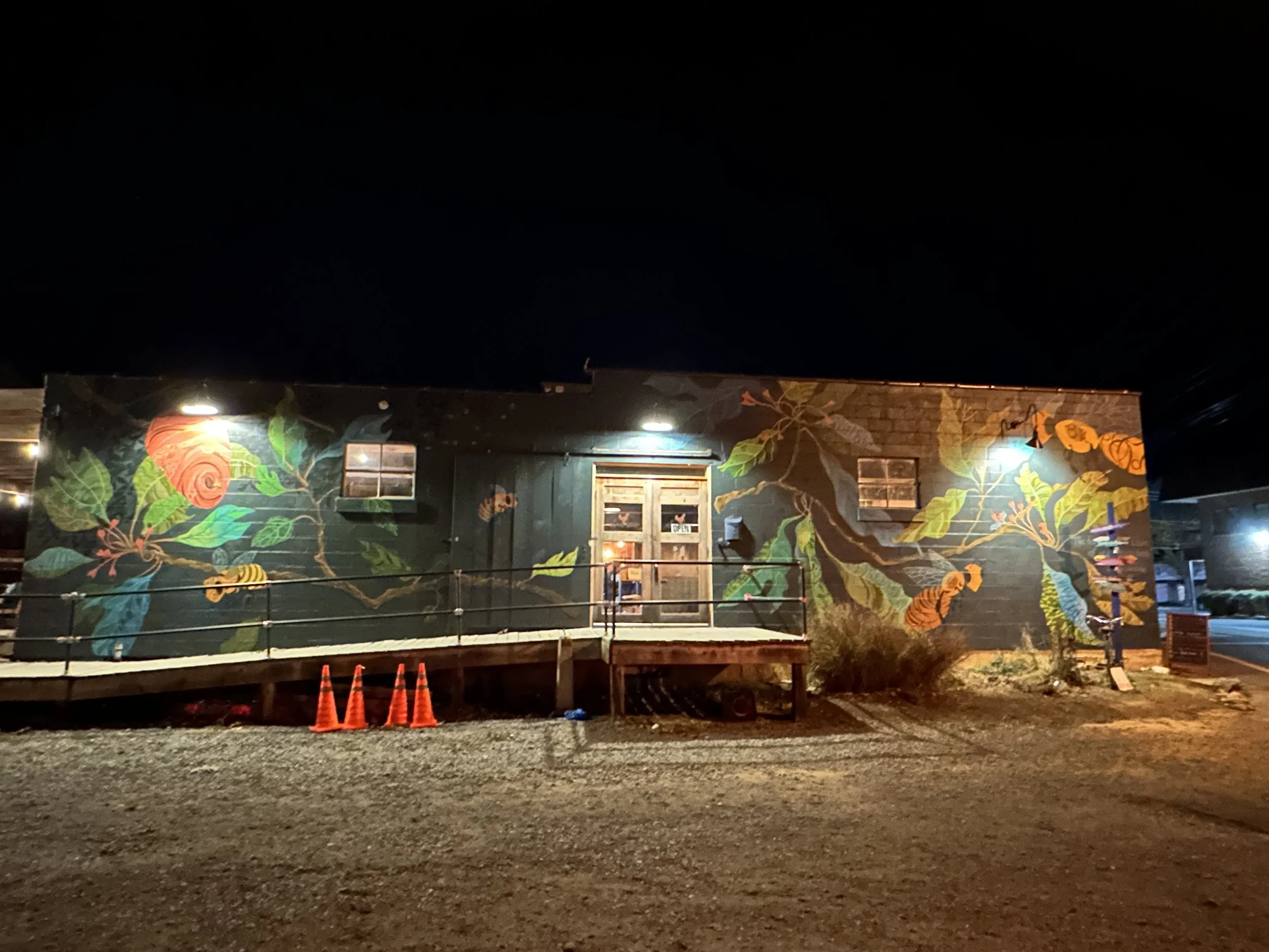 A full photograph of the Gateway Mural at night during dinner hours. The barn door moves to connect with the mural on the wall.