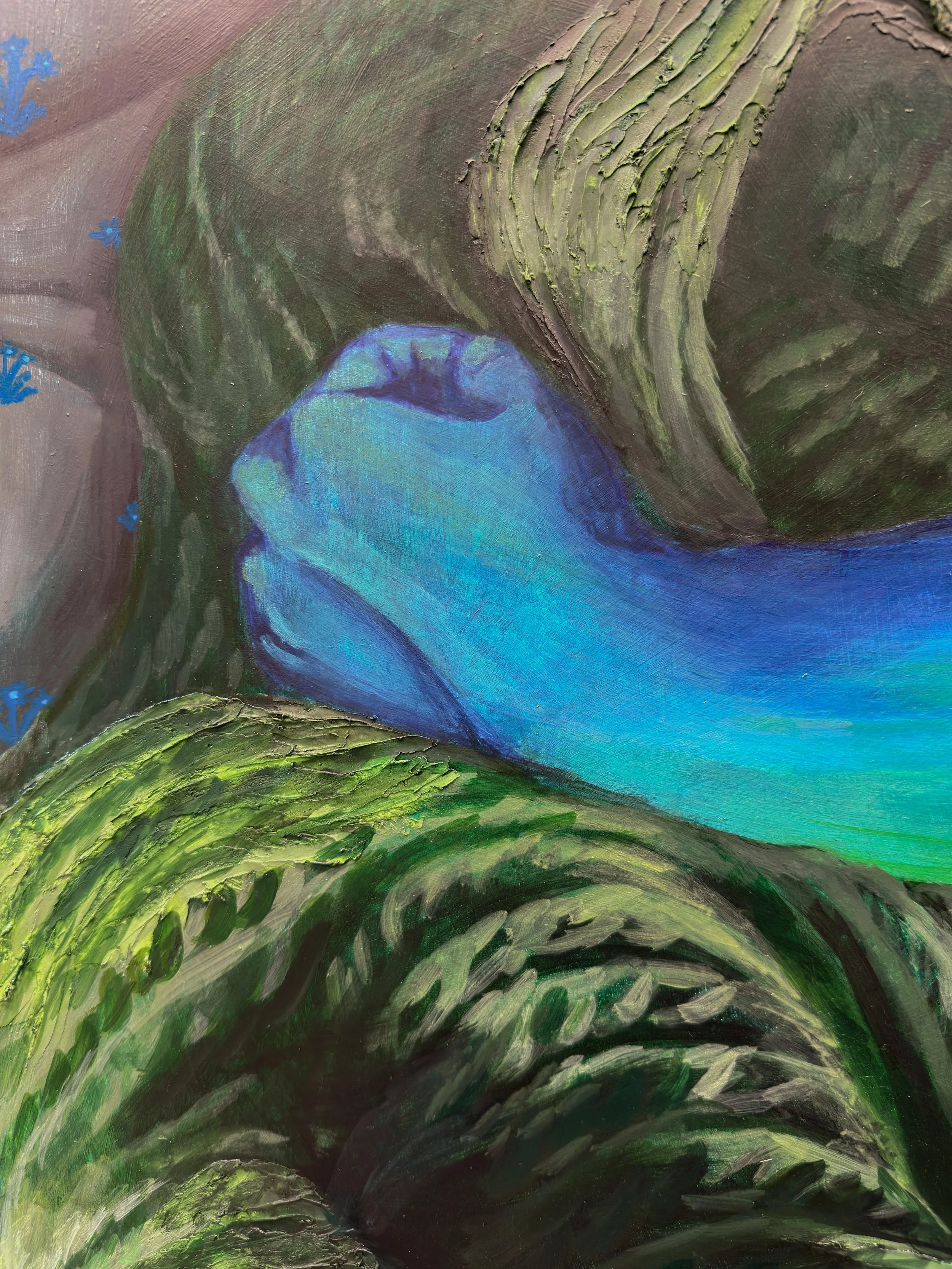 Close up on a blue hand at ease on top of a green blanket from the piece, "Never Been So Warm."