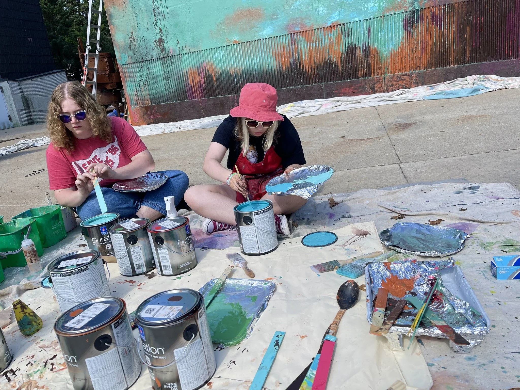 Charity mixing paint for the aurora on the Dream Big Mural