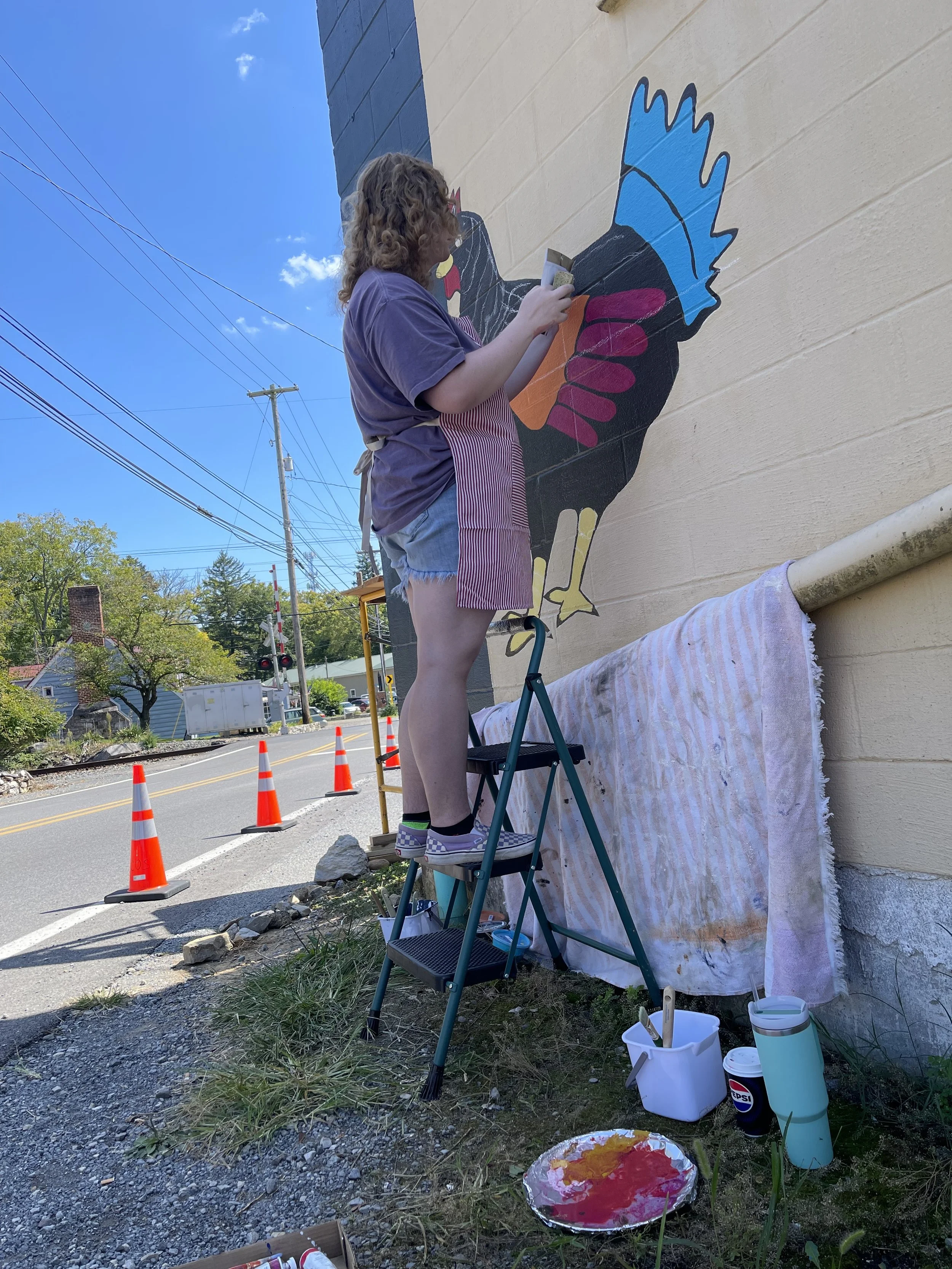 Charity painting the Alma Bea logo on the side of its location