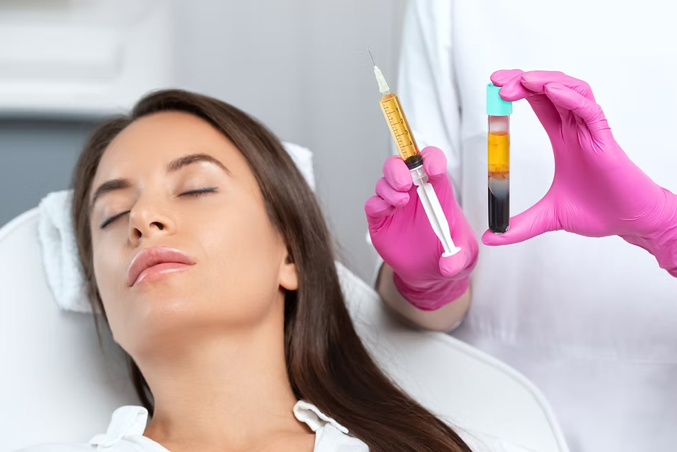 A woman with closed eyes lying on a medical bed, receiving a cosmetic treatment. A healthcare professional, wearing pink gloves, holds a syringe filled with a yellowish substance and a test tube containing a dark liquid, possibly related to the procedure.