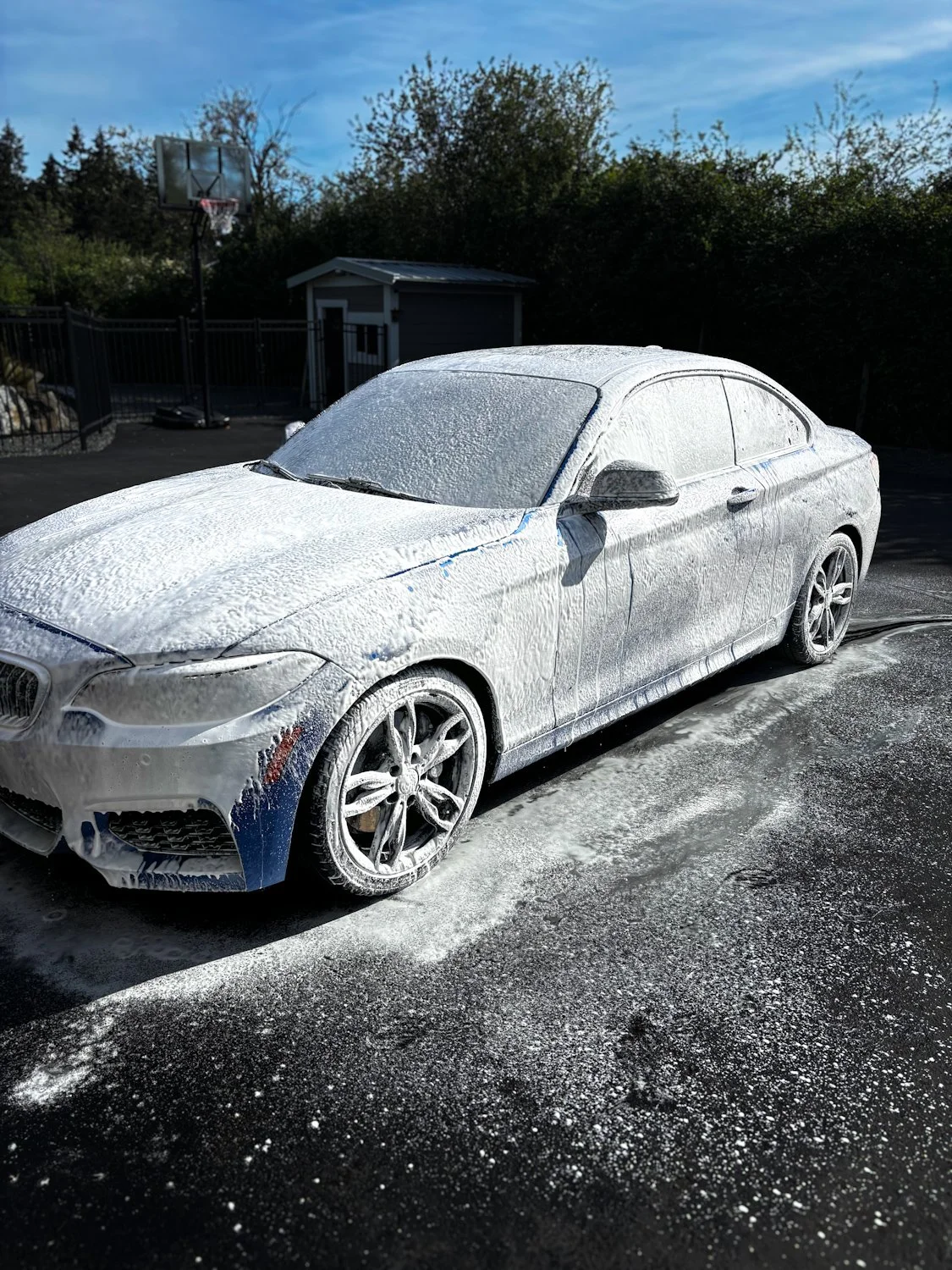 Blue BMW coated in spray foam wash
