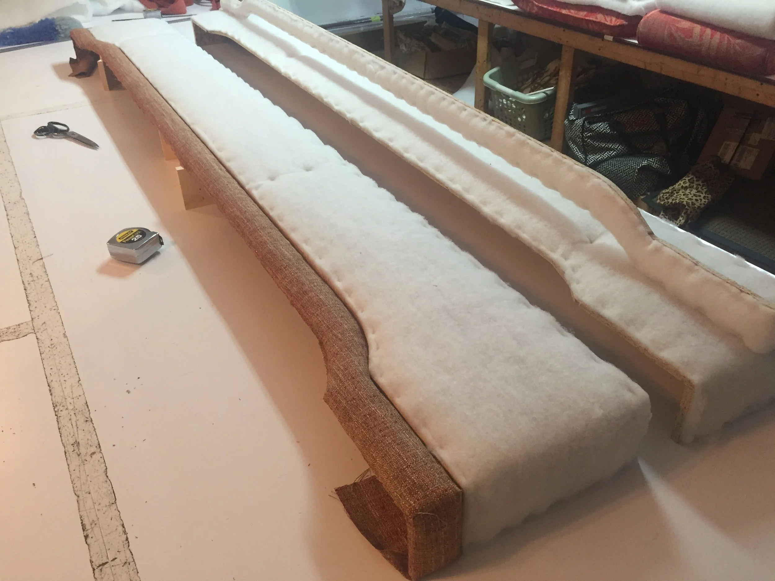 A partially assembled upholstered cornice being worked on in our Factory Direct Workroom.