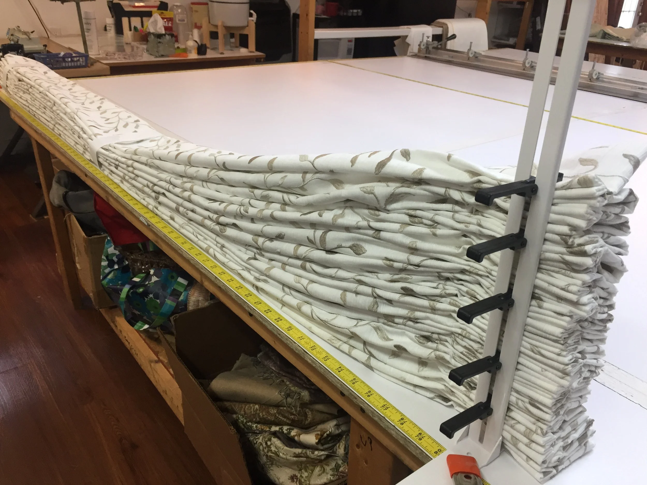 A pair of custom made draperies being fan folded before bagging.