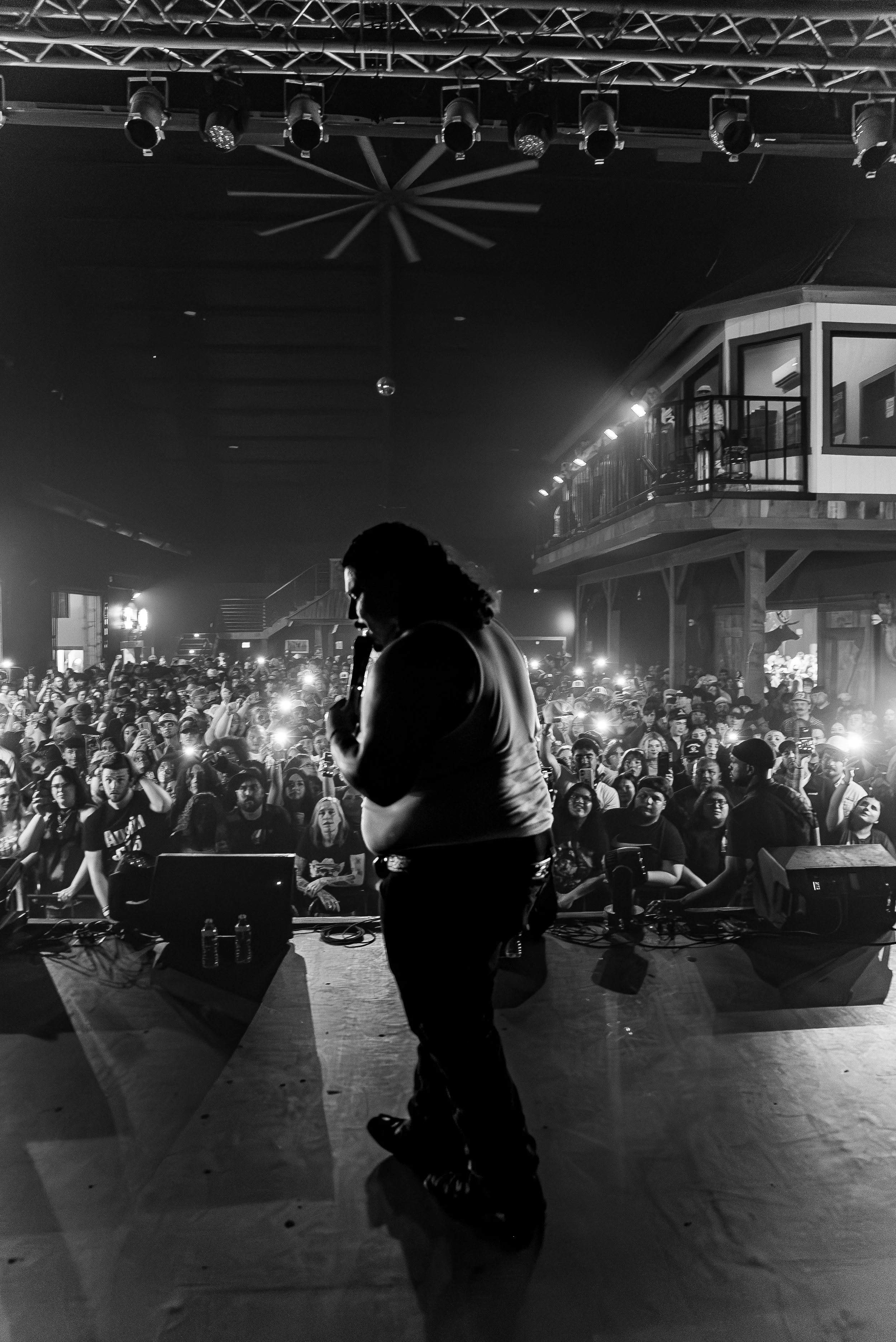 That Mexican OT in front of a large audience at an indoor concert, black and white photo.